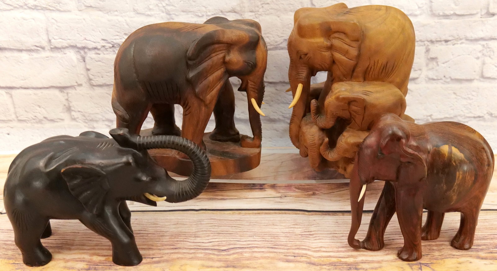 Lot of 4 Hand Carved Wooden Elephant Statues: Lot of 4 Hand Carved Wooden Elephant Statues. The tusk needs to be reattached to one elephant. Largest measures 11" tall. All invoices must be paid within 24 hours of the sale. We offer multiple shipp