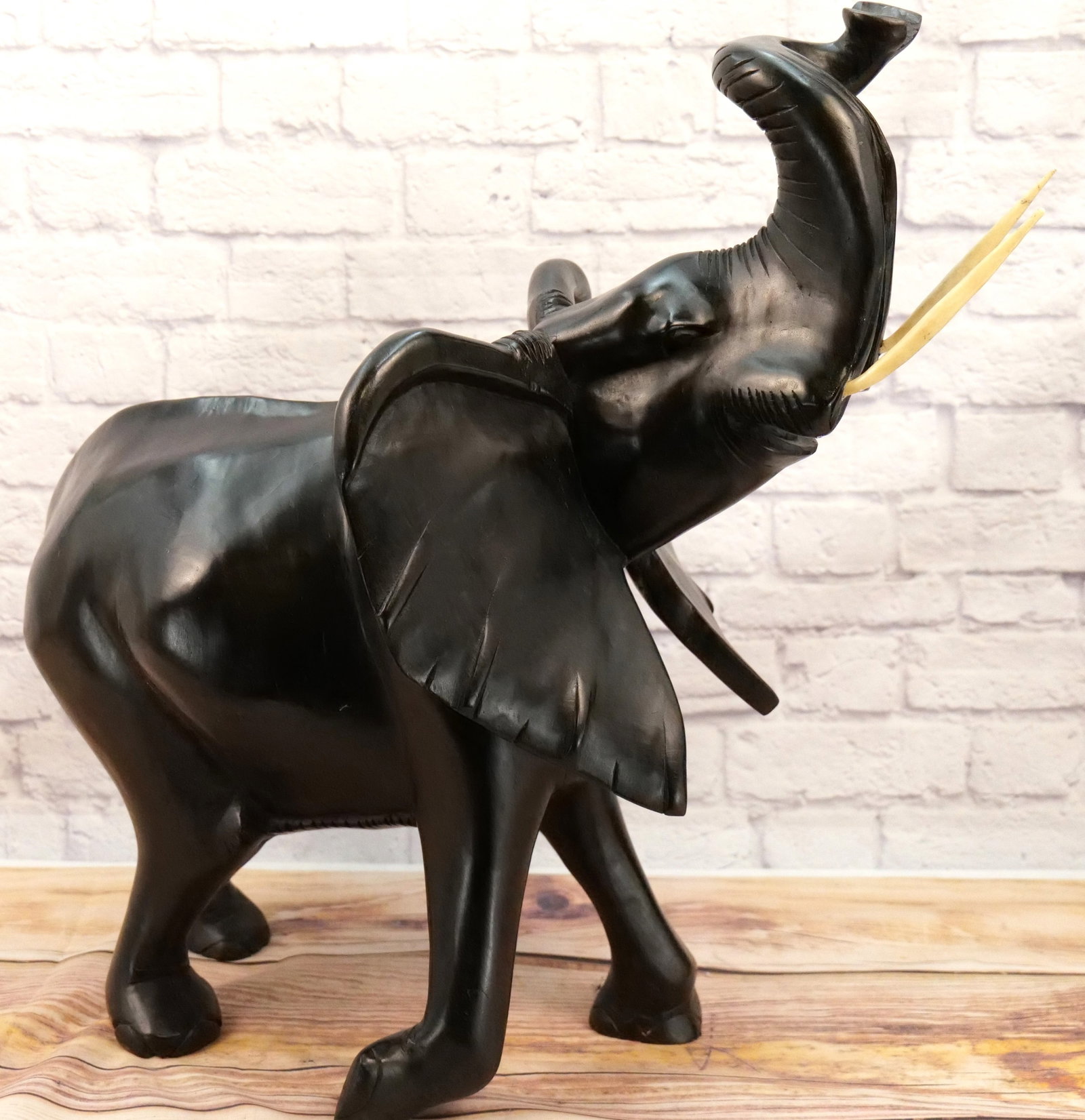 Oversized Hand Carved Elephant Statue: Oversized Hand Carved on Hard Wood Elephant Statue with Bone Tusks. Does have cracking on right side - See Photo. Measures 29" tall x 33" long. All invoices must be paid within 24 hours of the sale. W