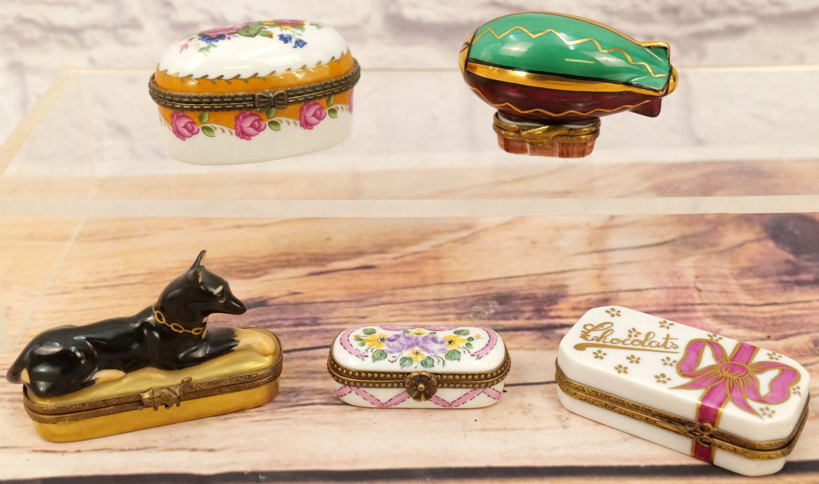 Lot of 5 Limoges Boxes: Group Lot of 5 Limoges Boxes including Blimp, Doberman Pincher, Egg Shape with Flower Design, Chocolates Box with Chocolates, and Elongated Flower Design Box. Largest measures 3" long. All invoices mu