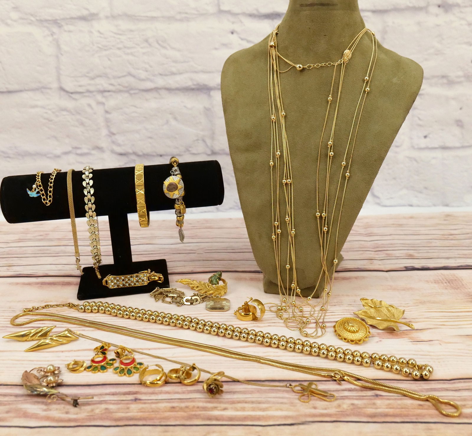 Lot of Mostly Gold Tone Costume Jewelry: Lot of Mostly Gold Tone Costume Jewelry. Including many earrings, bangles, interesting leaf pins, beaded necklaces and more. All invoices must be paid within 24 hours of the sale. We offer multiple sh