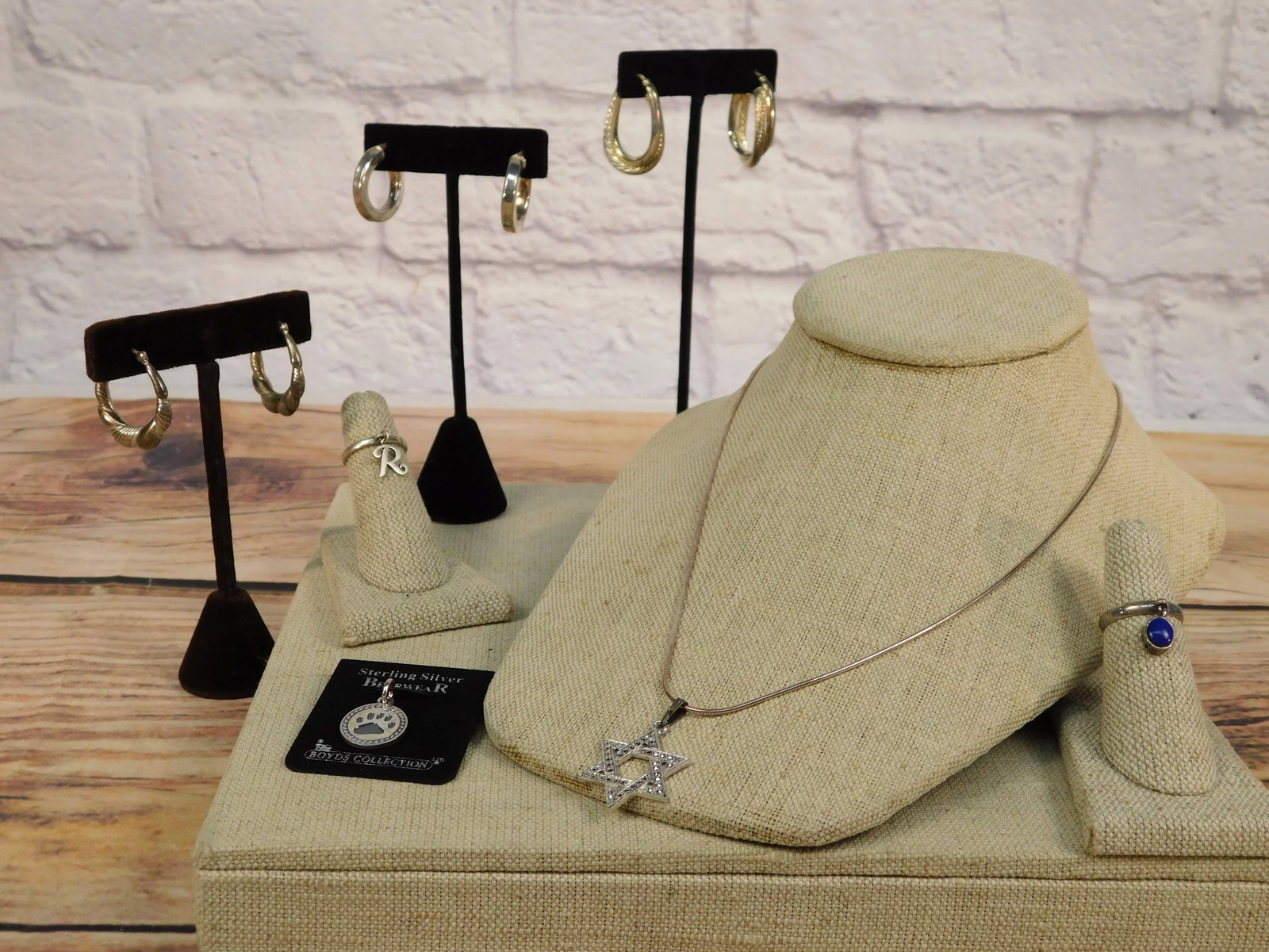 Group of Sterling Jewelry: Group of Sterling Jewelry including a carded small bear paw charm from Bearwear by Boyd's Collection, a star of David pendant with marcasite on an Italian made 18'' long liquid sterling chain, a stack