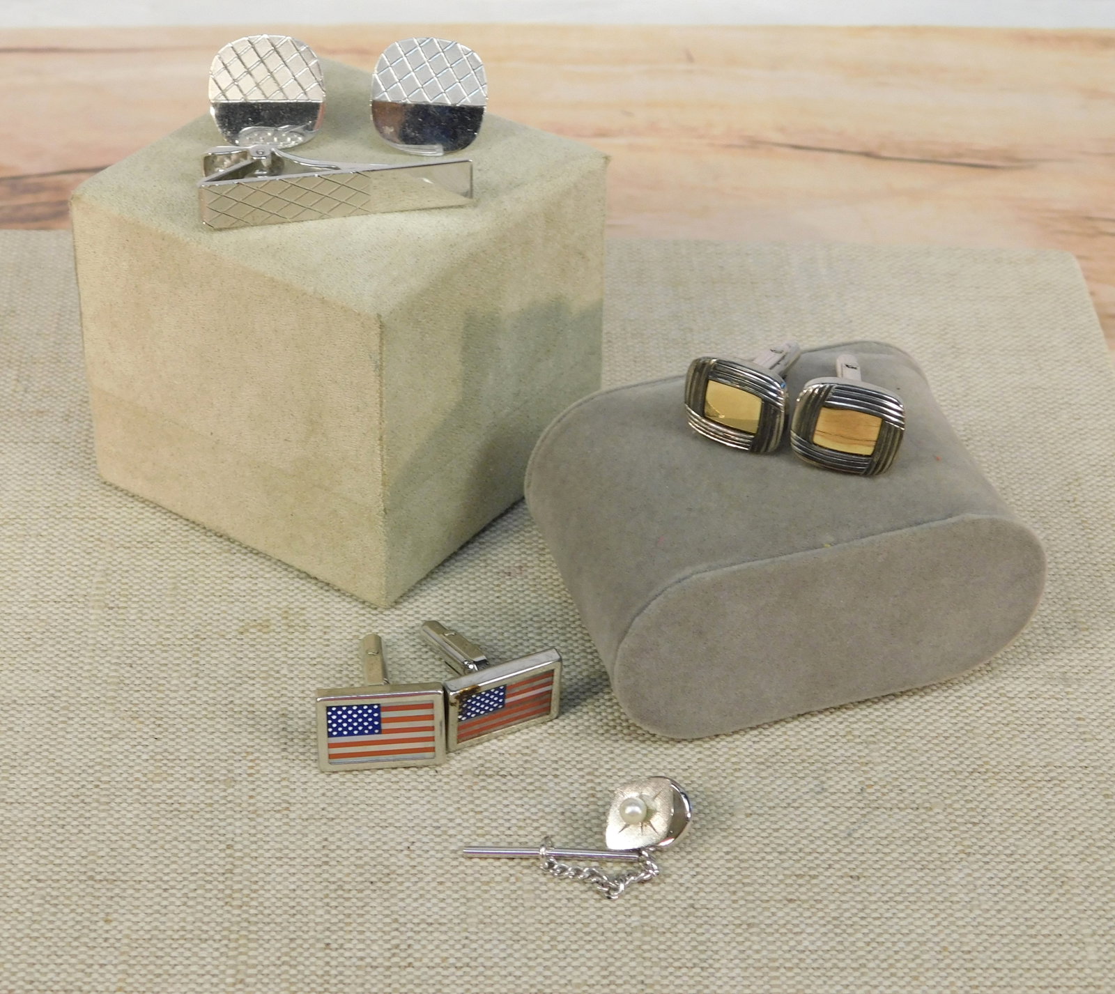 Group of Sterling Men's Jewelry: Group of sterling men's jewelry including American flag cufflinks, sterling cufflinks with 14K centers, a pair of sterling polished and cut finished cufflinks with a matching tie bar and a sterling an