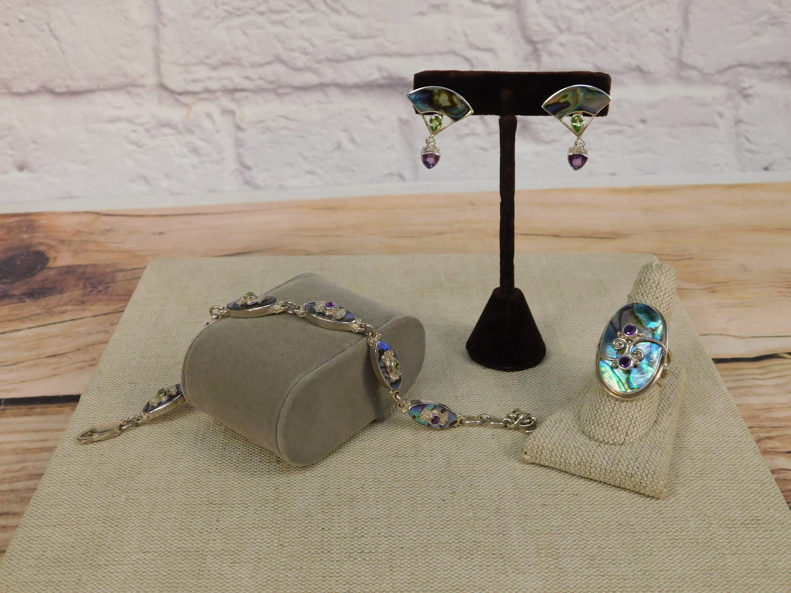 Group of Sterling Sajen Jewelry: Group of sterling Sajen jewelry including a pair of sterling abalone inlaid earrings with pear shaped Peridot and Trillion Cut amethyst drop earrings, a sterling ring with an oval inlaid abalone with