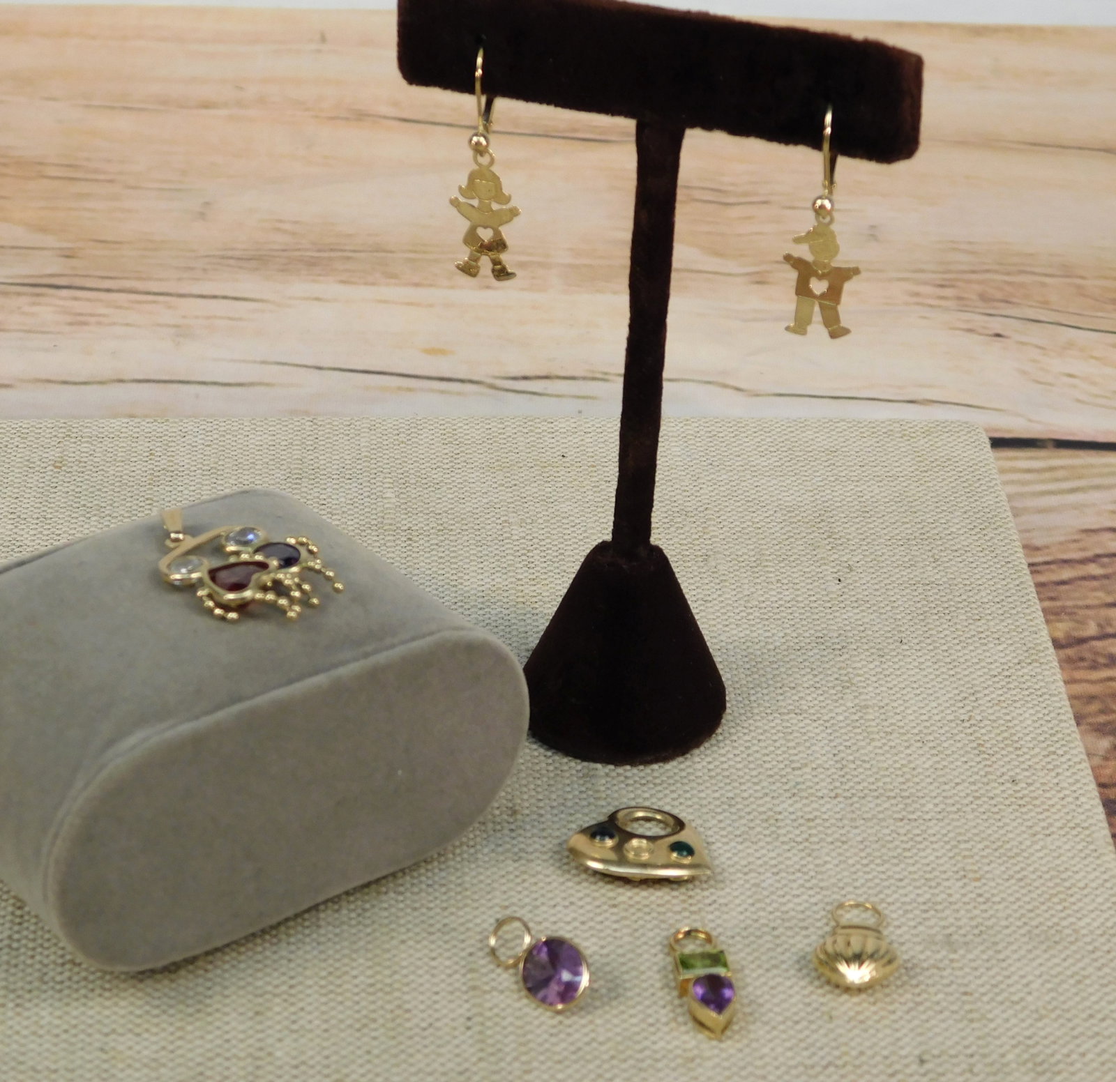Group of 14k Charms and More: Group of 14k Charms and More. Including a Small 14k Stacked Pendant set with Peridot and Amethyst measuring .78" high x .27" wide, an Oval Cut Amethyst Charm measuring .67" high x .34" wide, a Hollow 
