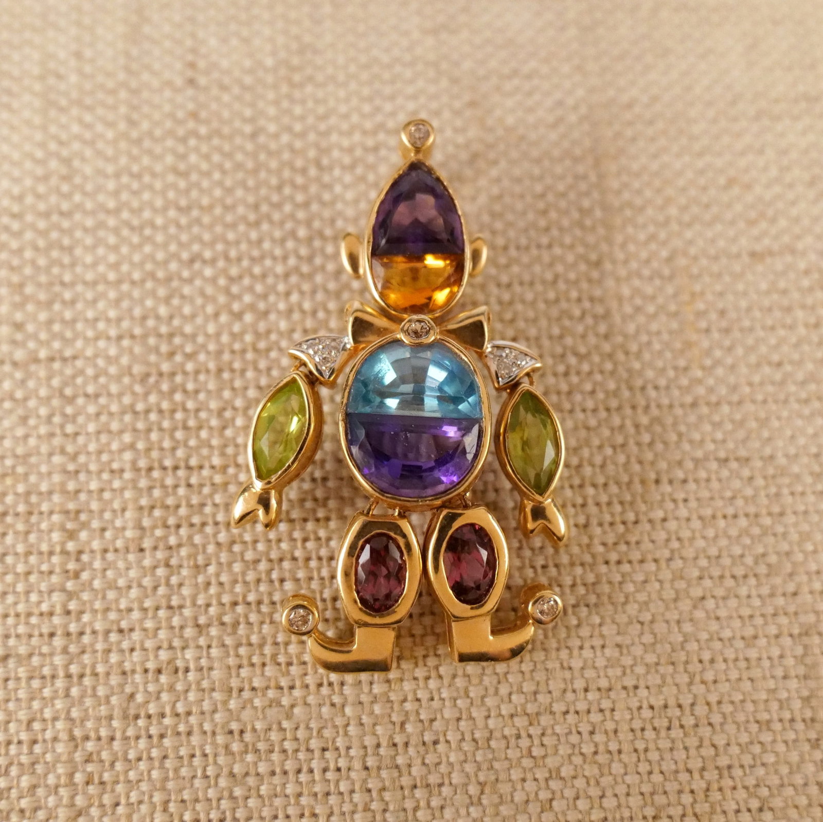 14K Yellow Gold and Gemstone Clown Pendant/Brooch: 14K Yellow Gold and Gemstone Clown Pendant/Brooch. An articulated 14K yellow gold clown pendant featuring a hinged bail, locking C clasp and a mix of bezel set amethysts, peridots, citrines, garnets, 