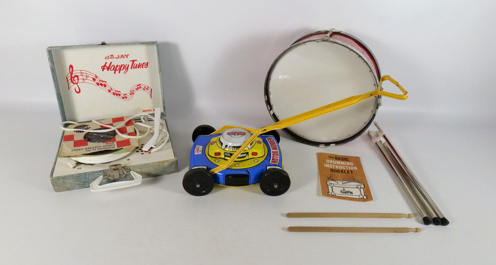 Mixed Lot of Toys/Collectibles: Mixed Lot of Toys/Collectibles including Chein Drum Set with Original Box and Instructions, Chein Tin Lawn Mower Toy, and deJay Happy Tunes 45 Disc Player. All invoices must be paid within 24 hours of