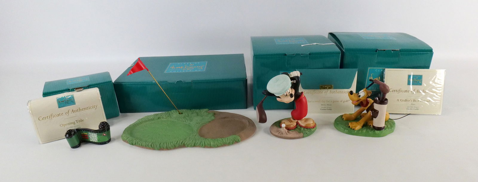 Set of 4 WDCC Canine Caddy Figurines: Set of 4 WDCC Walt Disney Classics Collection Canine Caddy Figurines including "What a Swell Day for a Game of Golf" Mickey Mouse, "A Golfer's Best Friend" Pluto, "Opening Title" and "Base". Largest m