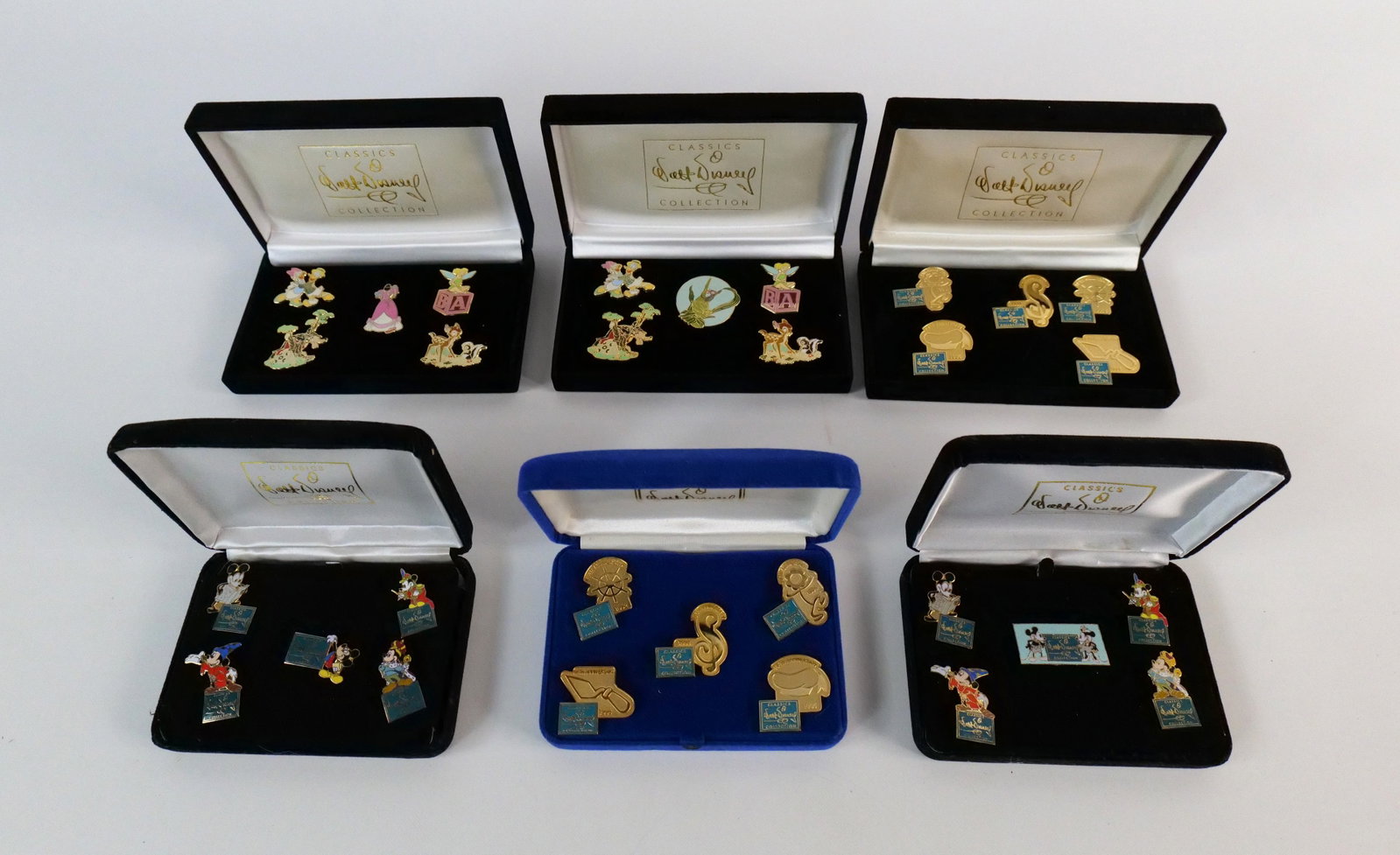 Lot of 6 Commemorative WDCC Pin Sets: Lot of 6 Commemorative WDCC Pin Sets including Cinderella Dress, 1st Five Years, Mickey Through the Years, Bambi, and More. All come with the cases. All invoices must be paid within 24 hours of the sa