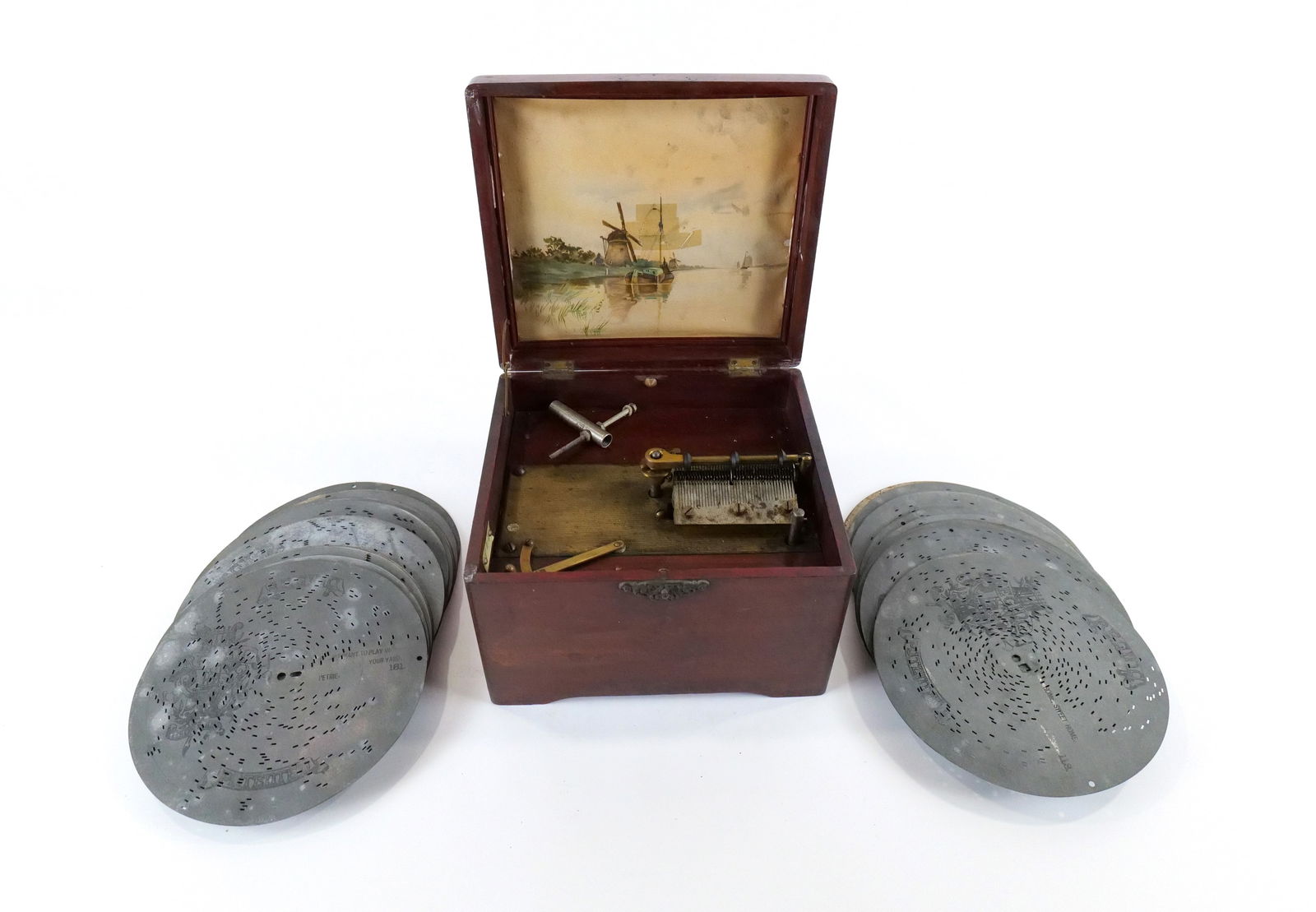 19th Century Disc Player Music Box: 19th Century Disc Player Music Box. Has paper portrait of sailing ships and windmill on the inside of lid - Has been taped repaired. Plays 8" disc. Comes with 32 discs. Has original key. Non-Working O