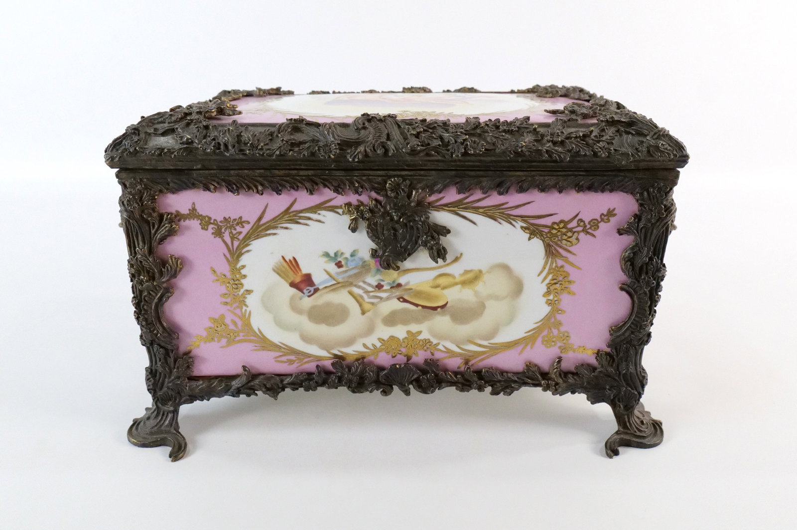 Late 20th Century Porcelain and Mixed Metal Dresser Box: Late 20th Century Porcelain and Mixed Metal Dresser Box. Portraits of Cherubs and Musical Designs. Cloth Interior. The rope lining is loose on the inside and can be easily reattached. Measures 8" tall