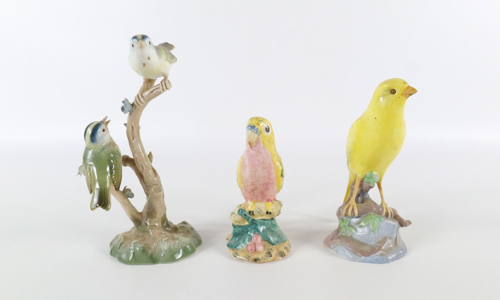 Group Lot of Bird Figurines: Group Lot of Bird Figurines including Stangl Bird Perched on Branch, Copeland Spode Goldfinch - Minor chip on base, and Unmarked Bird Grouping on Tree - Most likely German. Largest measures 7" tall. A