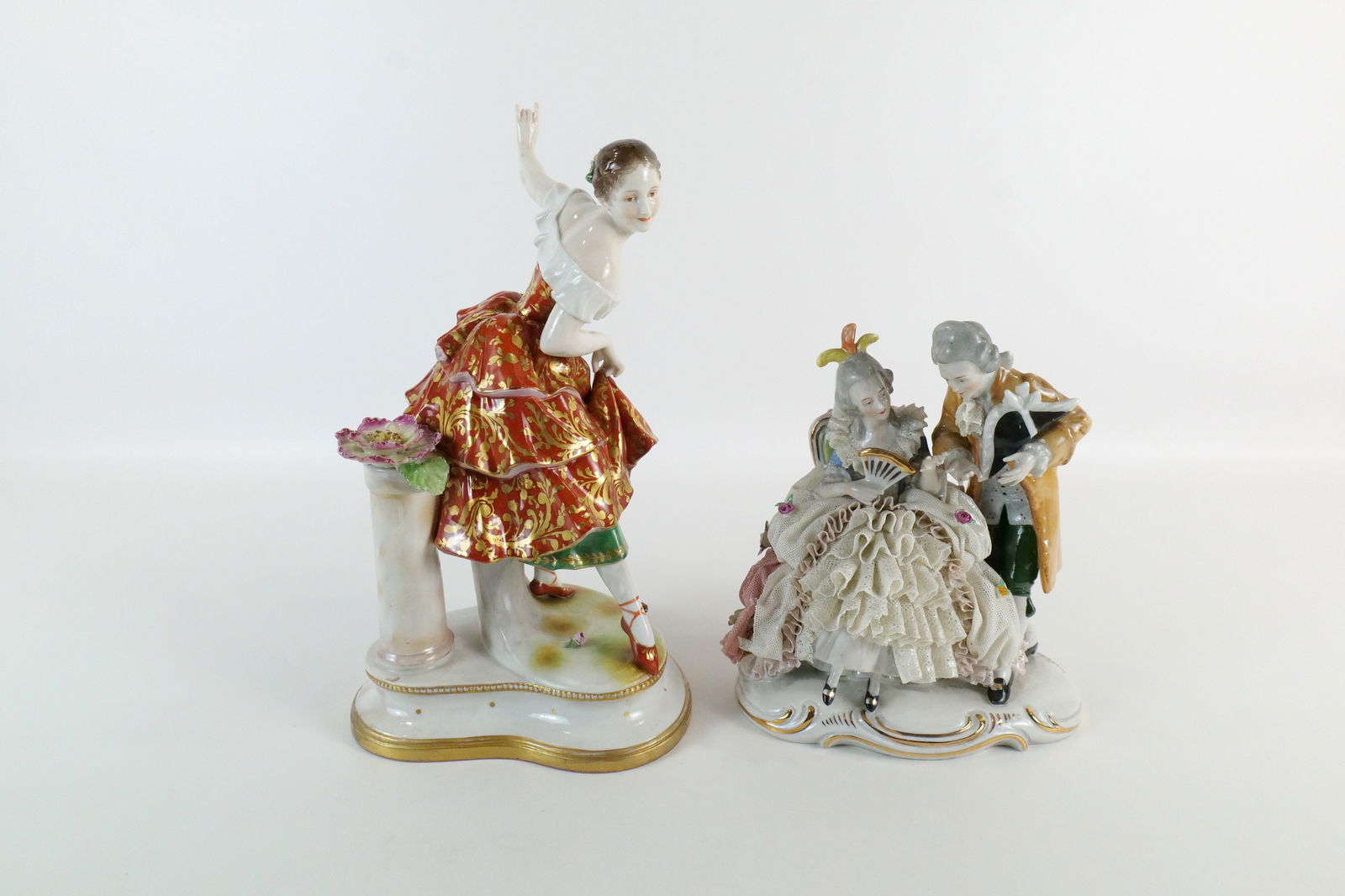 Lot of 2 19th Century German Porcelain Figurines: Lot of 2 19th Century German Hand Painted Porcelain Figurines. One depicts a Woman Dancing - Missing flowers in her hair and other is Dresden Style and depicts Man and Woman Seated - Some loss to lace