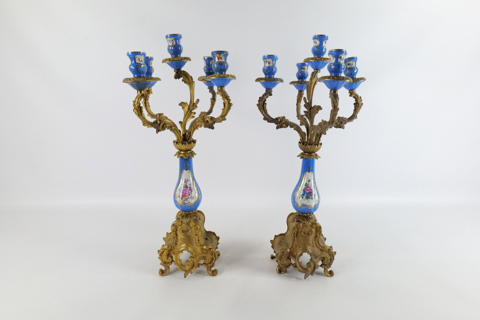 Pair of Sevres Style Bronze and Porcelain Candelabras: Pair of Sevres Style Bronze and Porcelain Candelabras. One base has been drilled for an electric lamp attachment. Both in good condition. Measures 25" tall x 12" wide. All invoices must be paid within