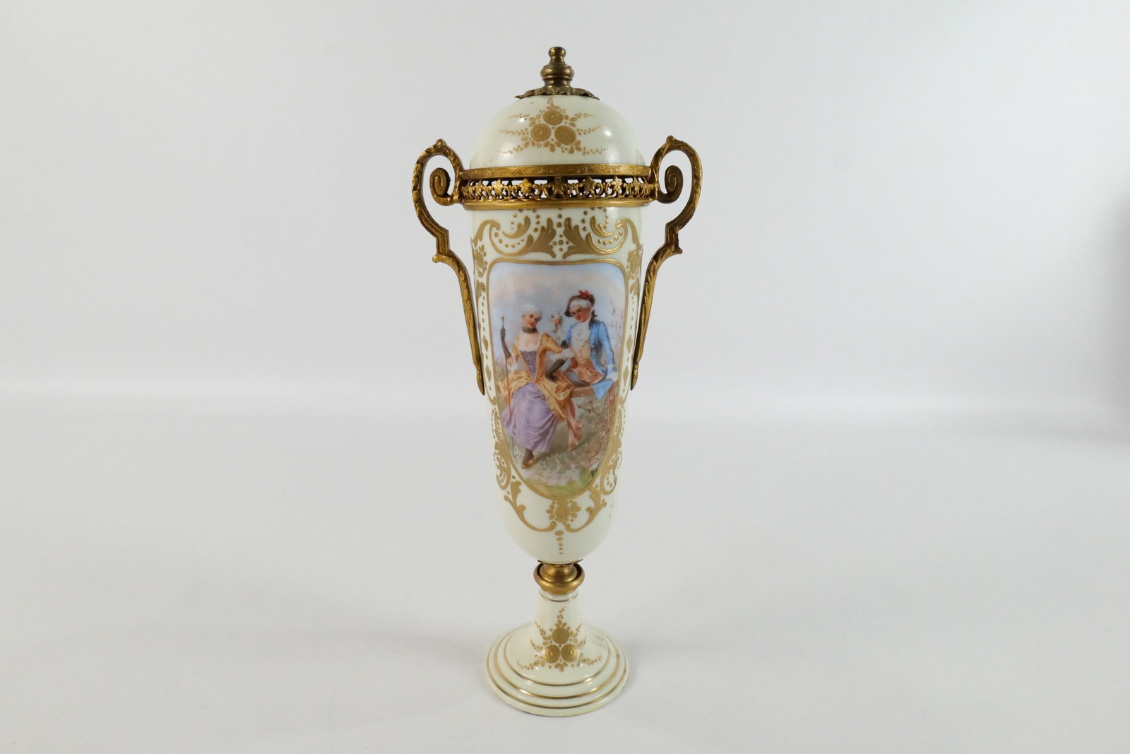 Antique Czechoslovakian Porcelain Urn: Antique Czechoslovakian Hand Painted Urn with Bronze Mounts. Depicting a portrait of a man and woman. Artist signed Lear. Marked on bottom. Good Condition. Measures 13.5" tall x 5.5" wide. All invoice