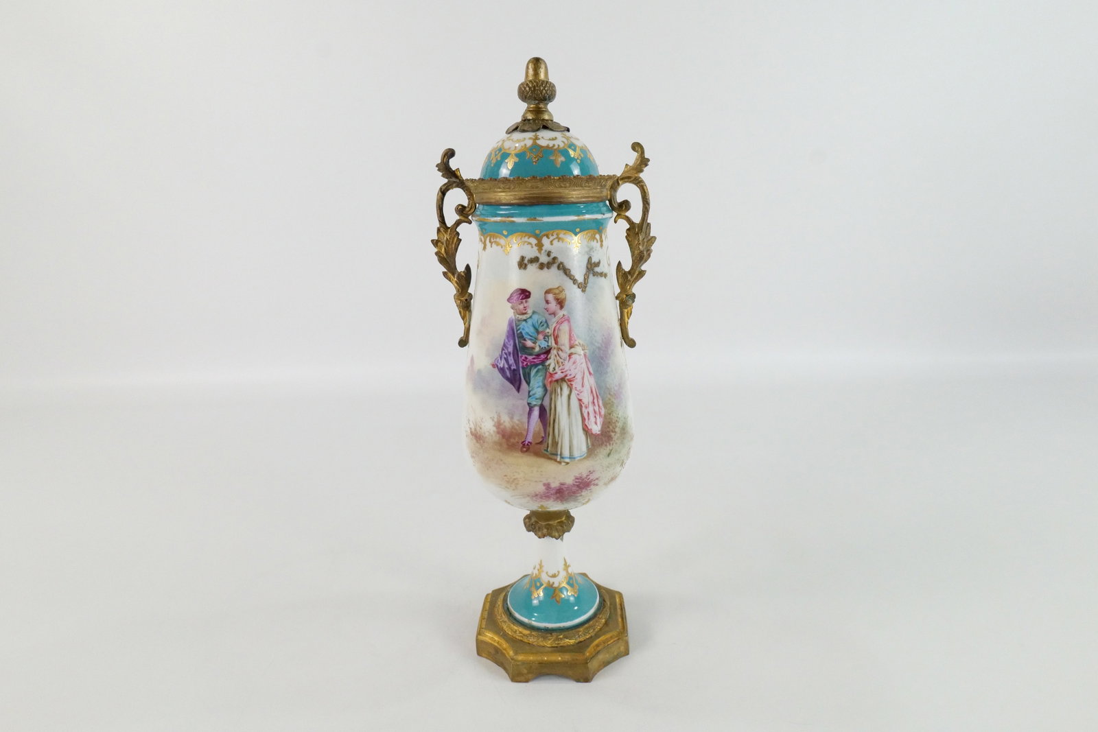 19th Century Sevres Porcelain Urn: 19th Century Sevres Hand Painted Double Handled Porcelain Urn. Depicting Man and Woman Walking. Artist Signed Rolli. Marked on Base - Sevres. Good Condition. Measures 13" tall x 4.5" wide. All invoice
