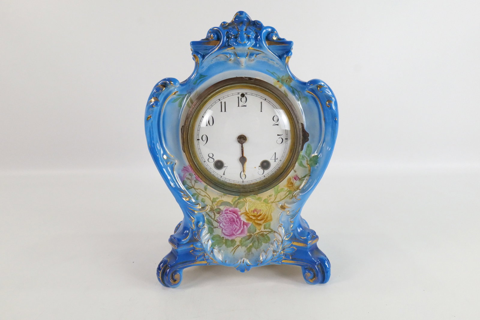 19th Century Royal Bonn Porcelain Mantle Clock: 19th Century Royal Bonn Porcelain Mantle Clock. Has Flower Decorations. Missing Hour Hand. Face has rusting. Missing back plate. Works appear to be rusted. Measures 12" tall x 8" wide. All invoices mu