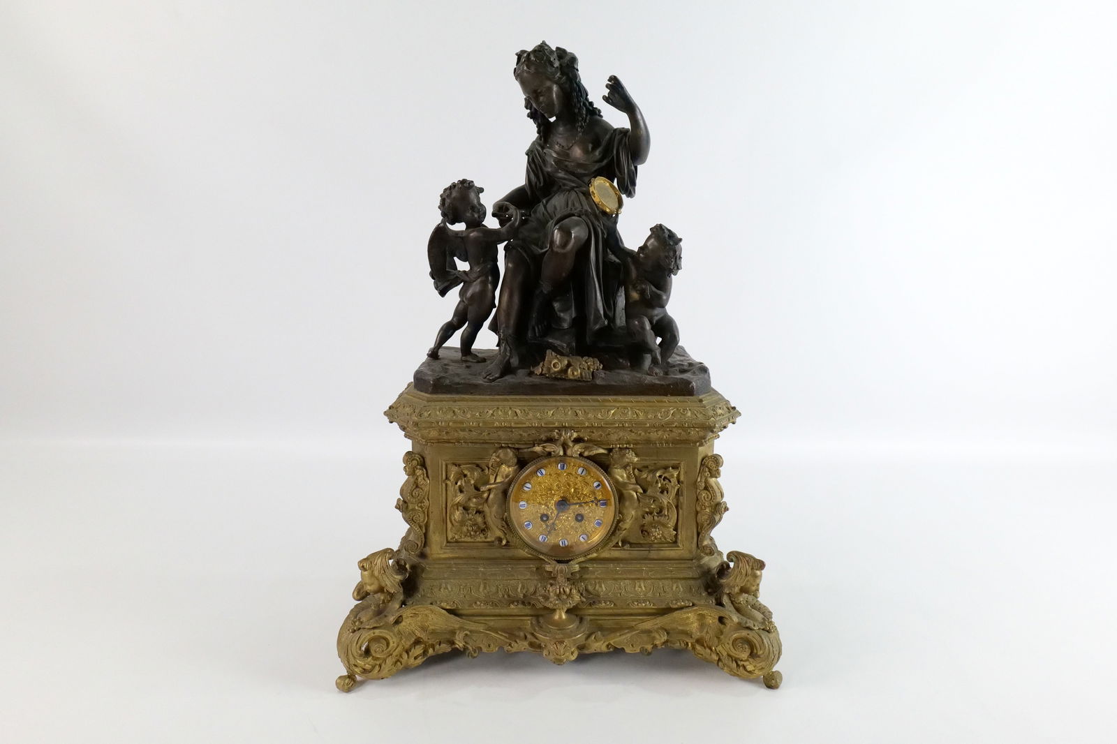 19th Century French Bronze Figural Mantle Clock: 19th Century French Bronze Figural Mantle Clock. Possibly Louis Phillipe. Spectacular Carved Base with Two Tone Bronze Top. Has enamel clock face numbers. No Pendulum. Measures 21" tall x 15" long. Al
