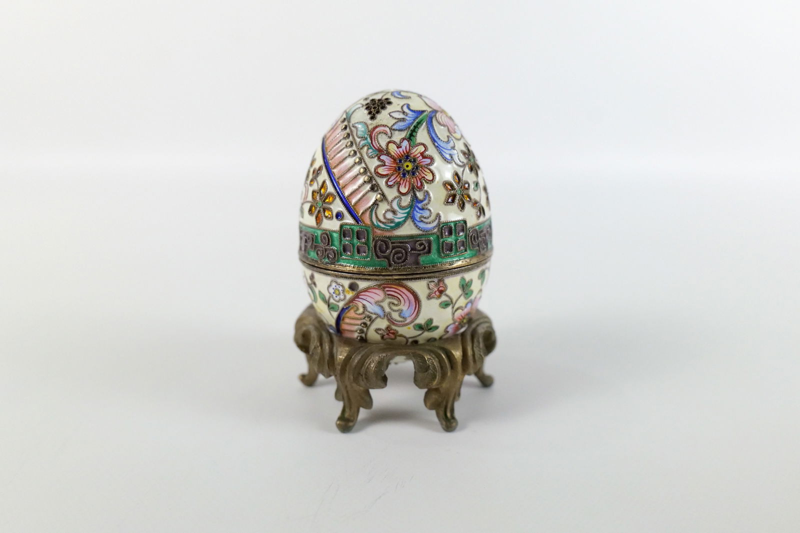 Russian Silver and Enamel Faberge Style Decorative Egg Box: Russian Silver and Enamel Faberge Style Decorative Egg Box. Flower Decoration. Unmarked. Has gold wash on the inside of the egg. Comes with Stand - Not original to egg. Measures 2.5" tall x 2" diamete