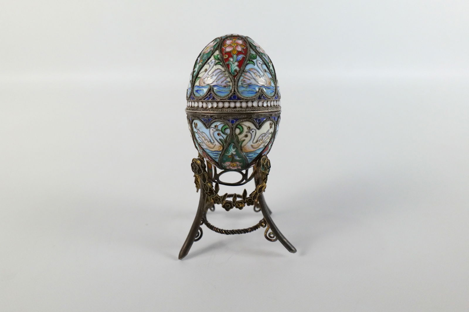 Russian Silver and Enamel Faberge Style Decorative Egg Box: Russian Silver and Enamel Faberge Style Decorative Egg Box. Swan and Flower Decoration. Unmarked. Comes with Stand - Not original to egg. Measures 2.5" tall x 2" diameter. All invoices must be paid wi