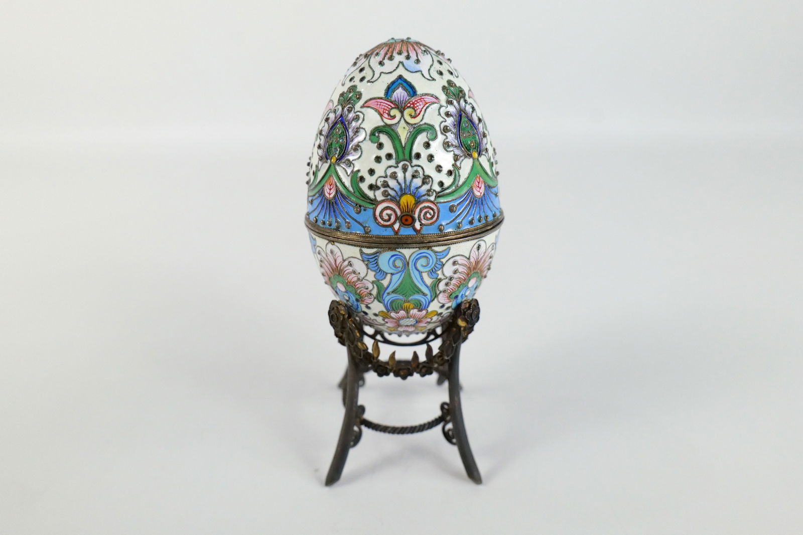 Russian Silver and Enamel Faberge Style Decorative Egg Box: Russian Silver and Enamel Faberge Style Decorative Egg Box. Flower Decoration. Unmarked. Has gold wash on the inside. Comes with Stand - Not original to egg. Measures 3" tall x 2" diameter. All invoic