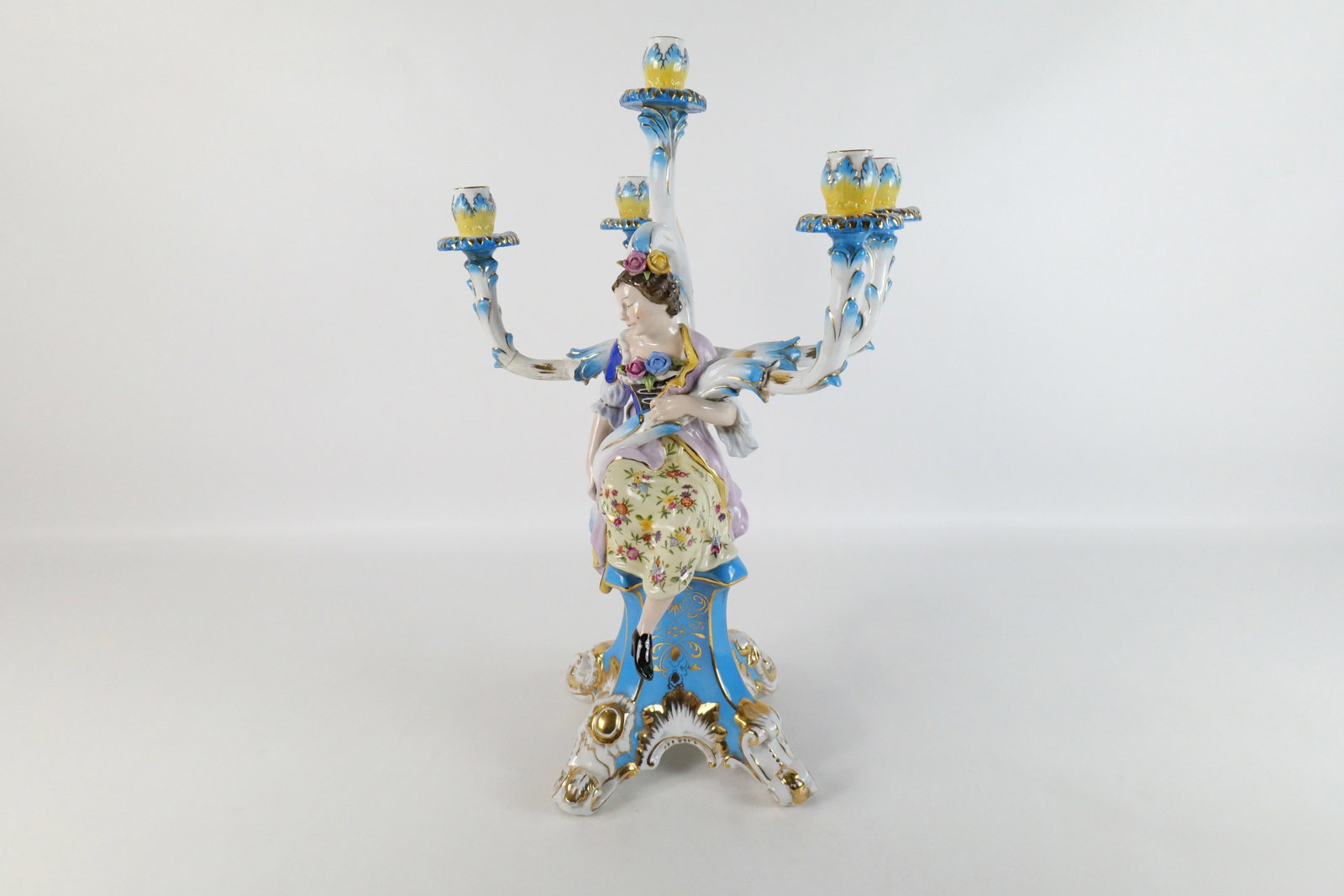 Porcelain Figural Candelabra: Porcelain Figural Candelabra. Depicting a woman seated on a pedestal. One arm has been repaired. Bears the signature Sevres. Measures 21" tall x 14" wide. All invoices must be paid within 24 hours of 