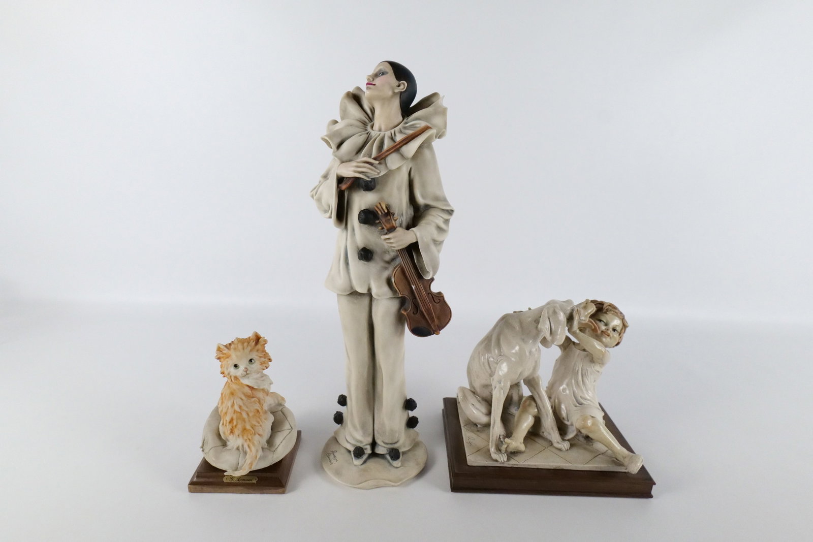 Lot of 3 Armani Figurines: Lot of 3 Armani Figurines including Vintage Dog Licking Girl's Face - Craze, Cat Figurine - Good Condition, "Pierrot Sonata" - Missing Base and Chipping to Violin and Chip on rim of sleeve. Largest me
