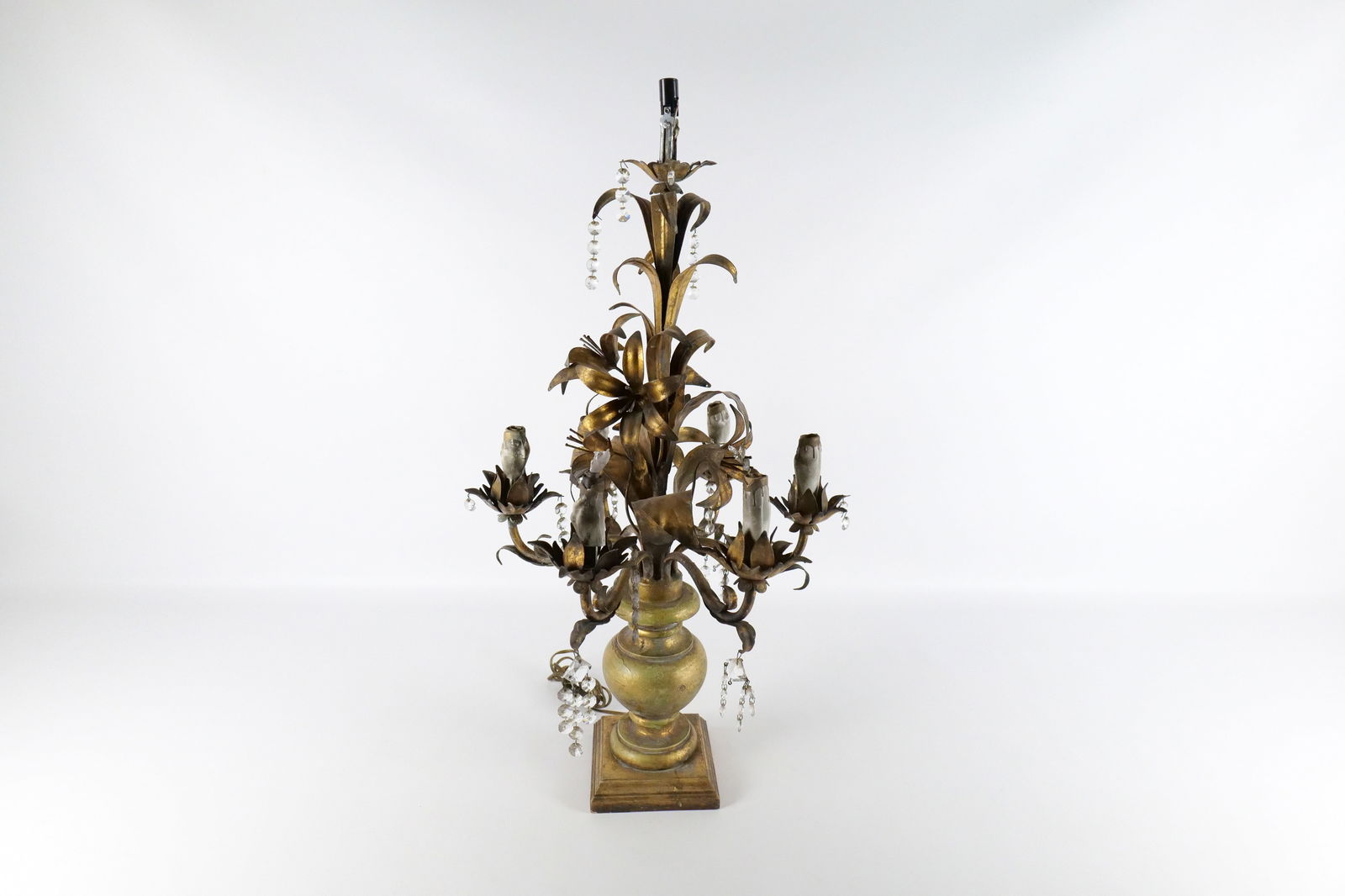 Vintage Table Lamp: Vintage Table Lamp. In the form of decorative urn with flowers in the middle. Made of wood and metal. Needs to be rewired. Does not have all the prisms. Measures 30" tall x 15" wide. All invoices must