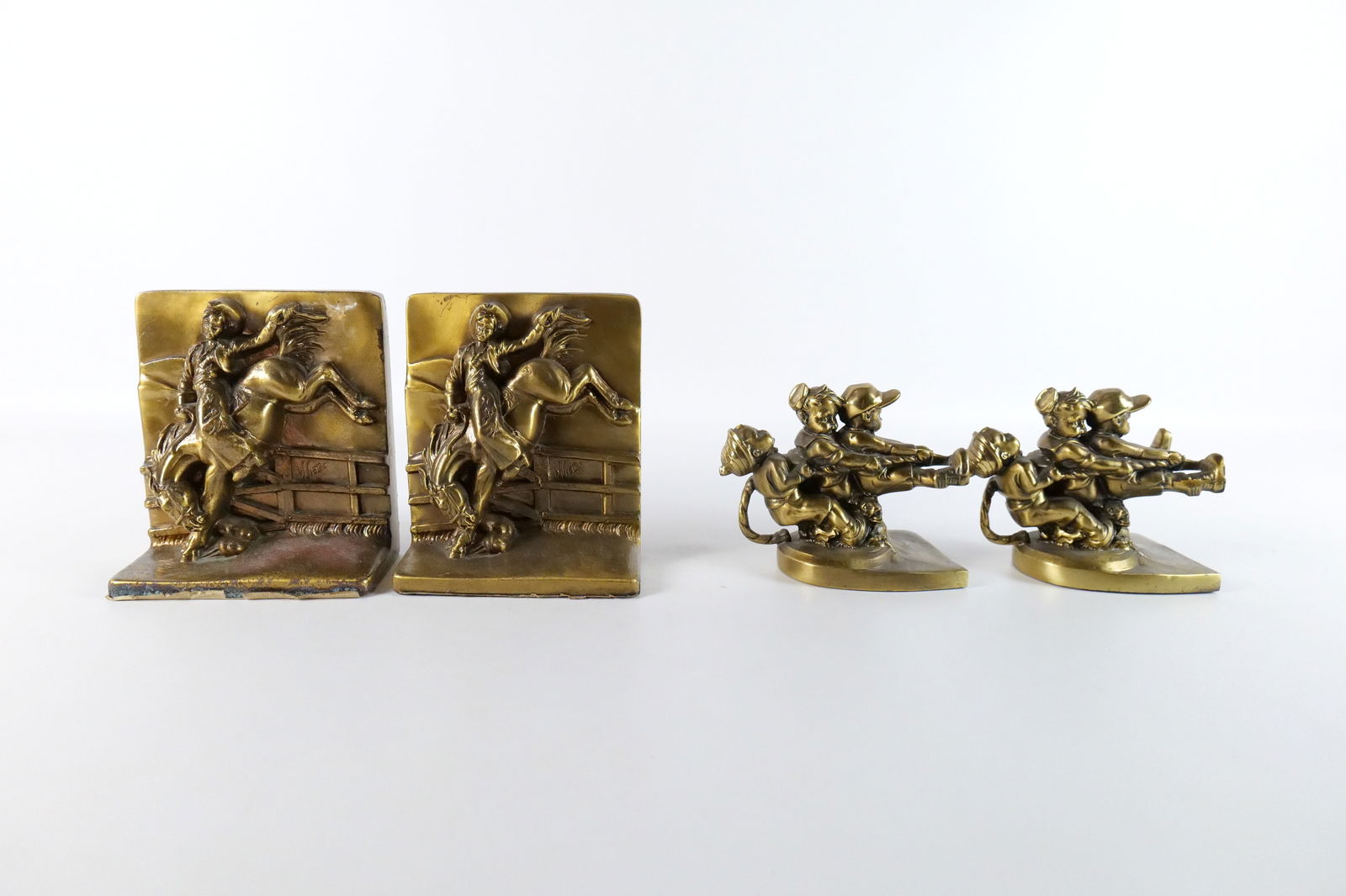 Group Lot of Mixed Metal Bookends: Group Lot of Mixed Metal Bookends including Pair depicting Man on Bucking Horse Back - After Victor and Pair of Bookends depicting Kids Playing Tug-O-War - One child is missing a leg. Largest measures