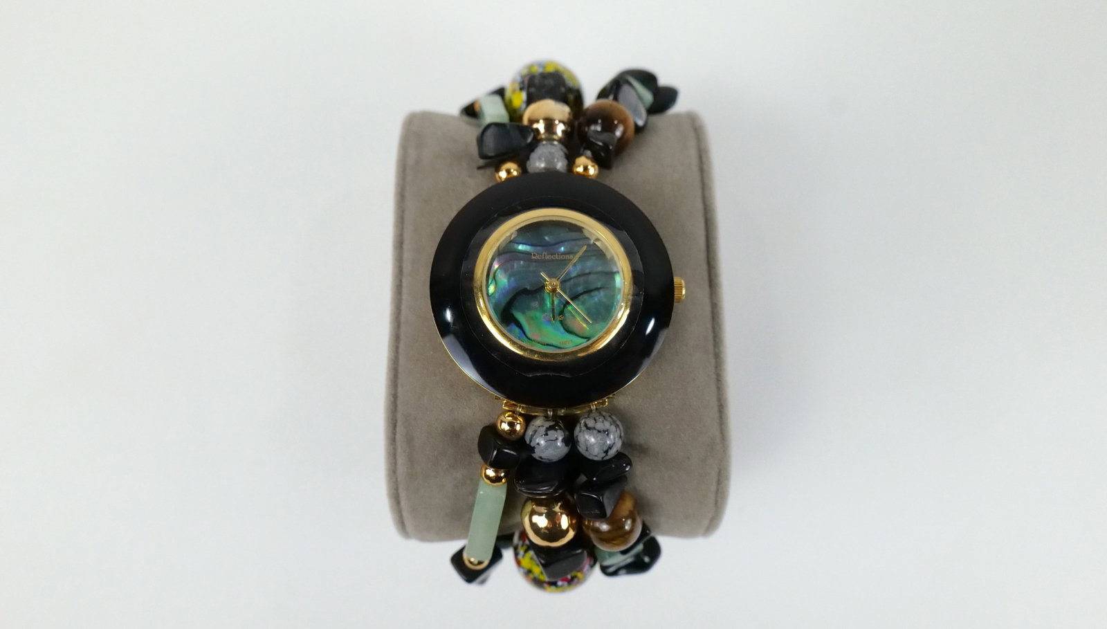 Onyx and Jade Ladies Watch: Onyx and Jade Ladies Watch. The lot includes an 8'' long ladies watch featuring a band made of 3 rows of jade, tigers eye, snowflake obsidian, gold tone beads, and art glass beads with onyx chips and 
