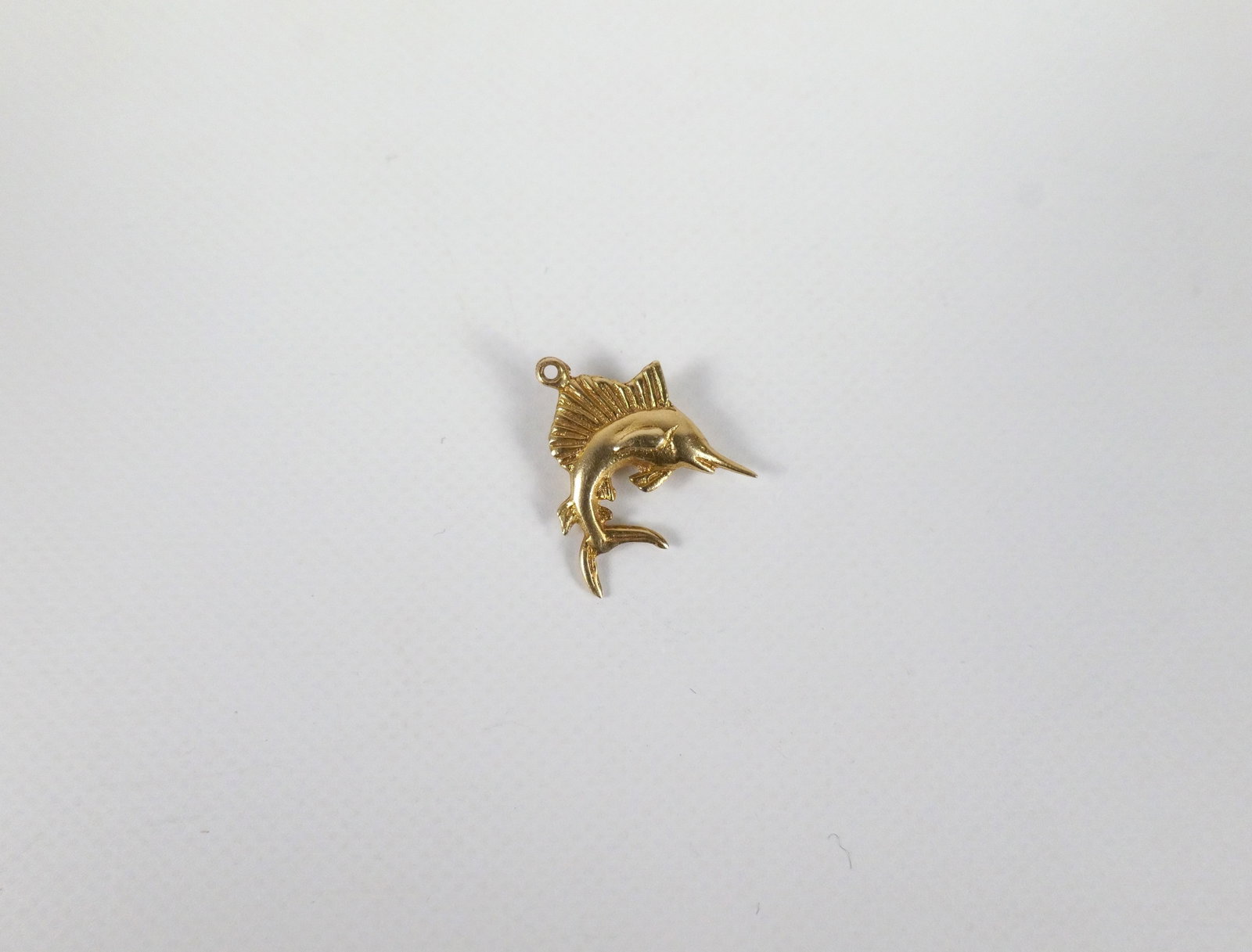 Vintage 18K Sail Fish Charm: Vintage 18K Sail Fish Charm. The lot includes a vintage mid century sail fish charm measuring .60'' x .53''. It weighs 1.4 grams and is unmarked but tested a 18K. Used. All invoices must be paid withi