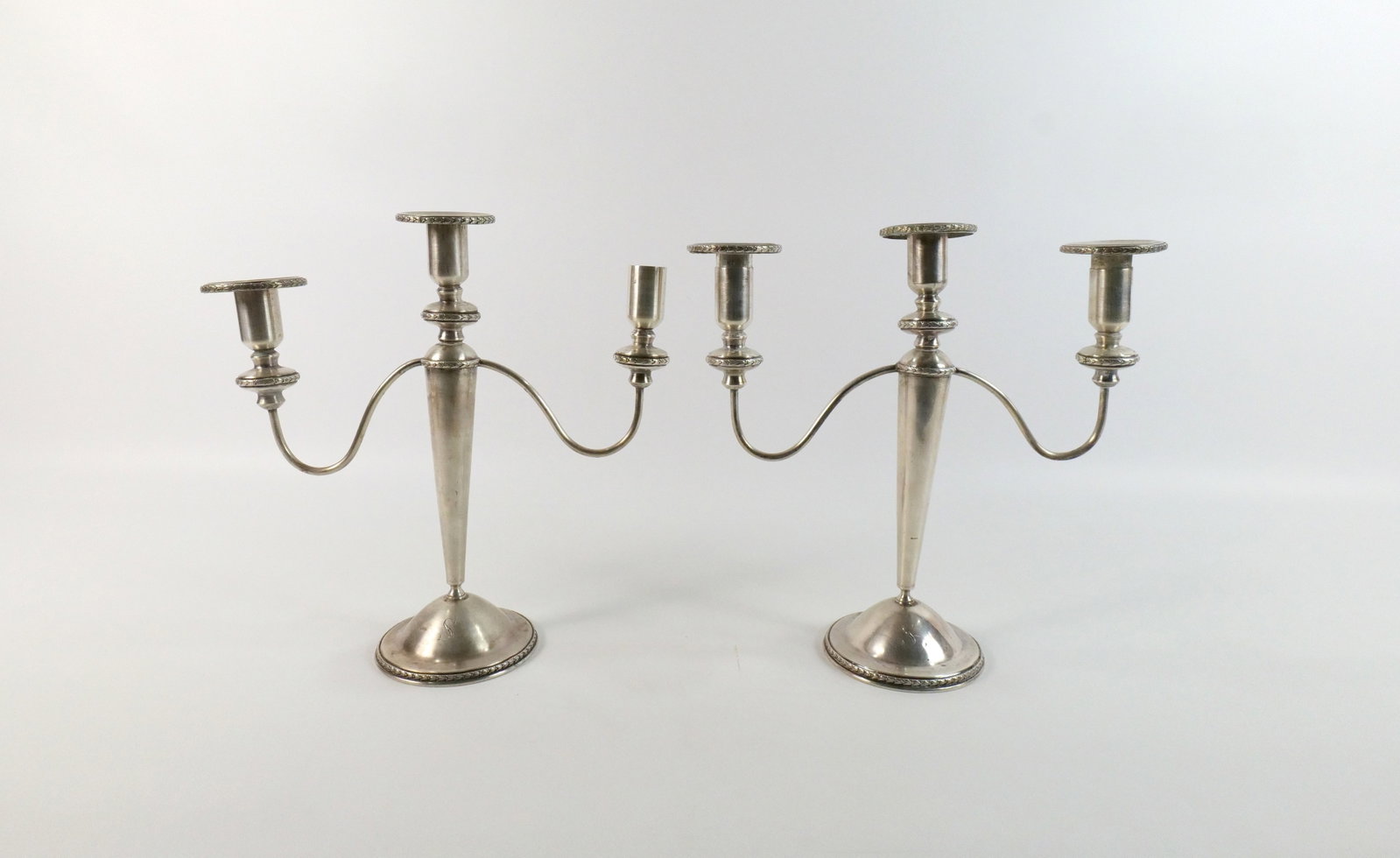 Pair of Sterling Silver Candelabras: Pair of Sterling Silver Candelabras. Monogrammed with the Letter S. Missing one wax collector. One is slightly bent and has minor denting. Most likely originally had cement bottoms. Now missing. Weigh
