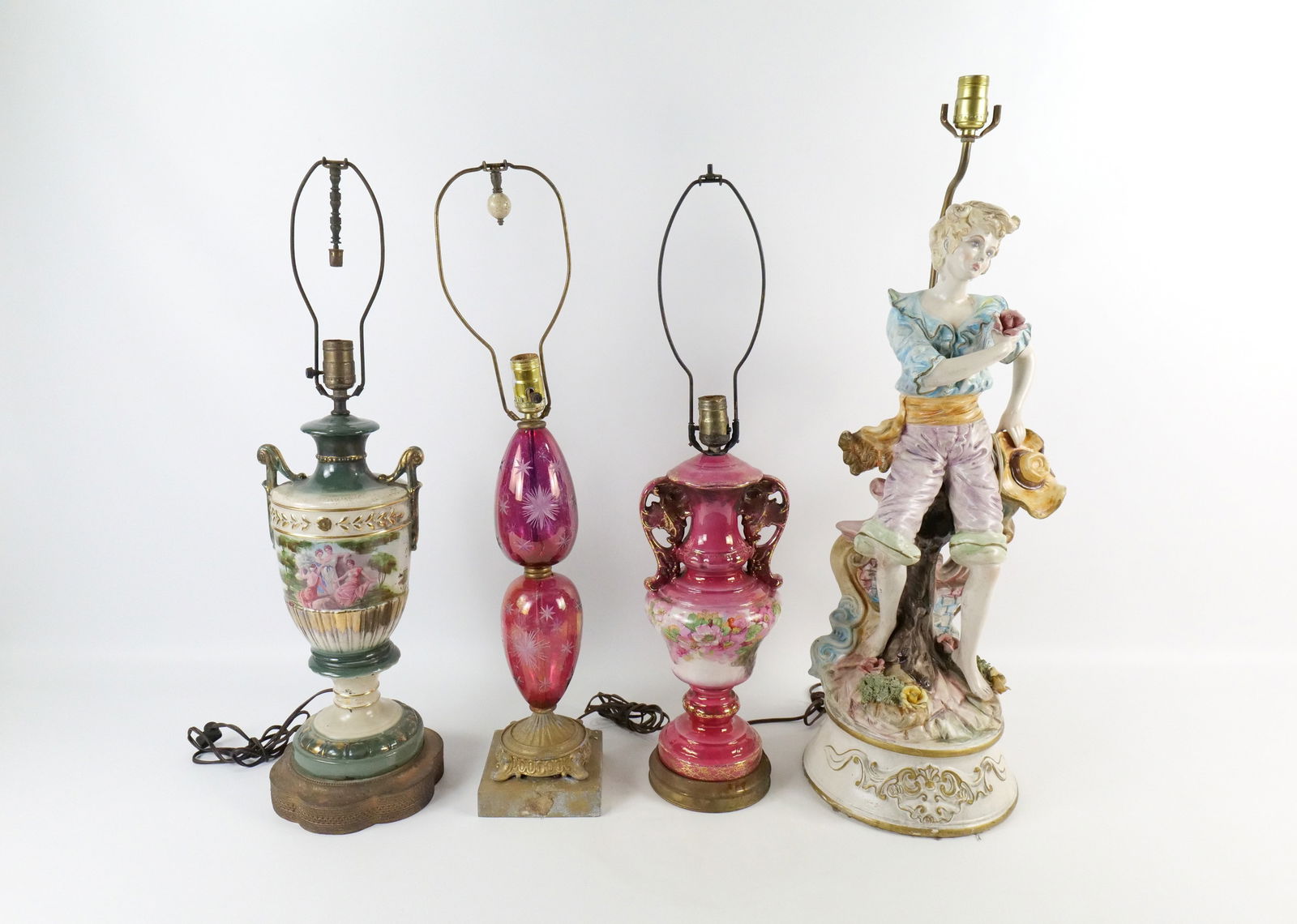 Group Lot of Decorative Lamps: Group Lot of Decorative Lamps. Lot includes Capodimonte Lamp depicting boy seated on a fence, Flash Ruby Table Lamp, and Pair of 1930's Hand Painted Urn Lamps. Capodimonte has some chips on flowers. A