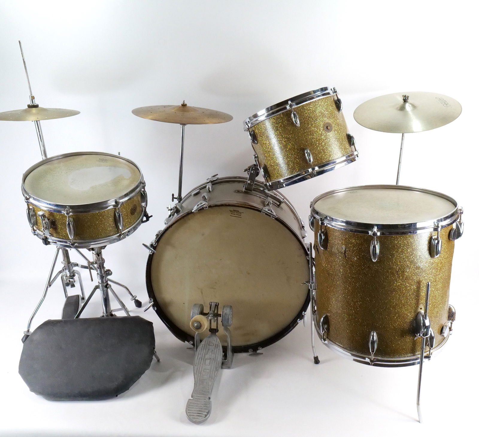 Vintage 1950's/60's 4 Piece Gretsch Drum Set: Vintage 1950's/60's 4 Piece Gretsch Drum Set. Set includes Bass Drum, 1 Floor Tom/1 Attached Tom, and 1 Snare Drum. Has a gold speckled design. Appears to be original. Has cracking to laminated design