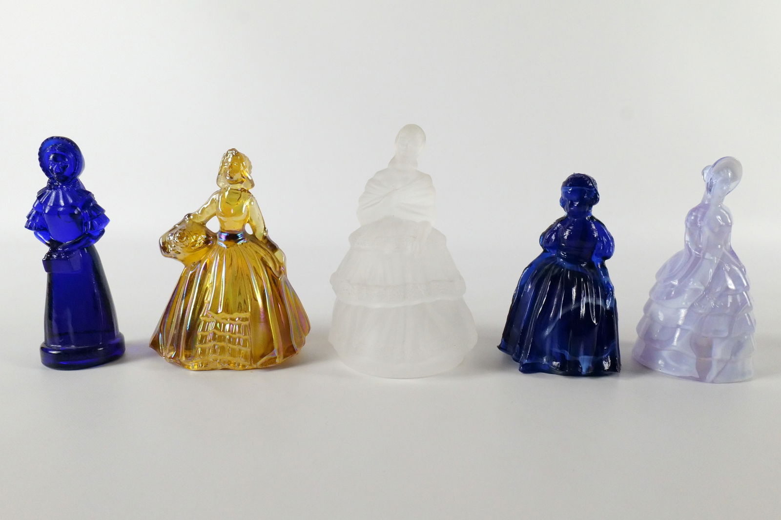 Lot of 5 Glass Lady Figurines: Lot of 5 Glass Lady Figurines. Including Wheaton Carnival Amber Glass Dutch Woman, Cobalt Blue Slag Glass Victorian Lady, Summit Alexandrite Slag Glass Colonial Lady, Degenhart Priscilla, and Royal Cr