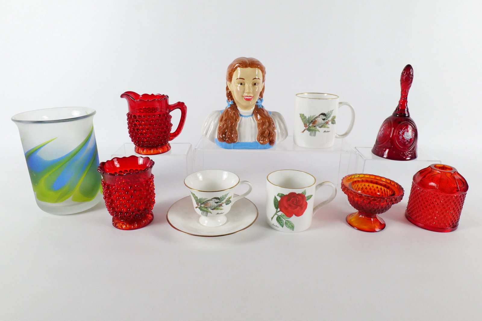Group Lot of Mixed Porcelain and Glass Items: Group Lot of Mixed Porcelain and Glass Items. Including (2) Boehm Coffee Mugs, Boehm Teacup and Saucer, Vandor Wizard of Oz Dorothy Bank, Mirage Vase by Goran Warff for Kosta Boda, Viking Glass Amberi