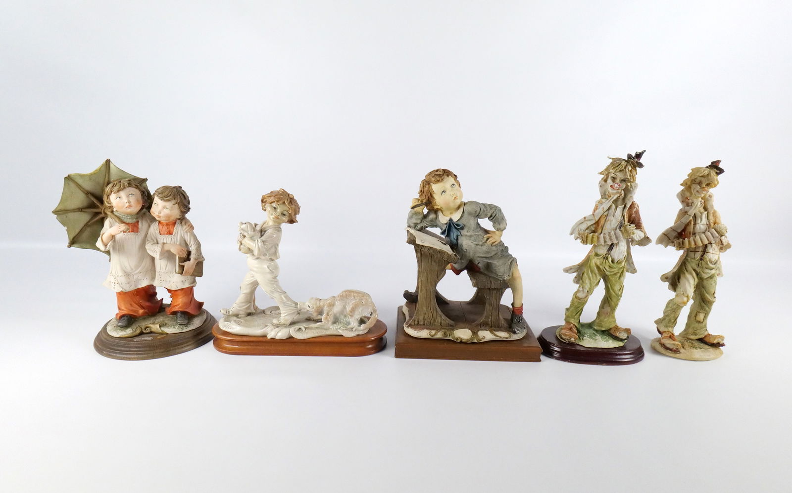 Lot of AS-IS Porcelain Figurines: Lot of AS-IS Porcelain Figurines. Including Armani/Capodimonte School Boy - Minor chipping on hair, Armani "The Choir Boys" - Chip on Umbrella and missing part of umbrella handle and chipping on book