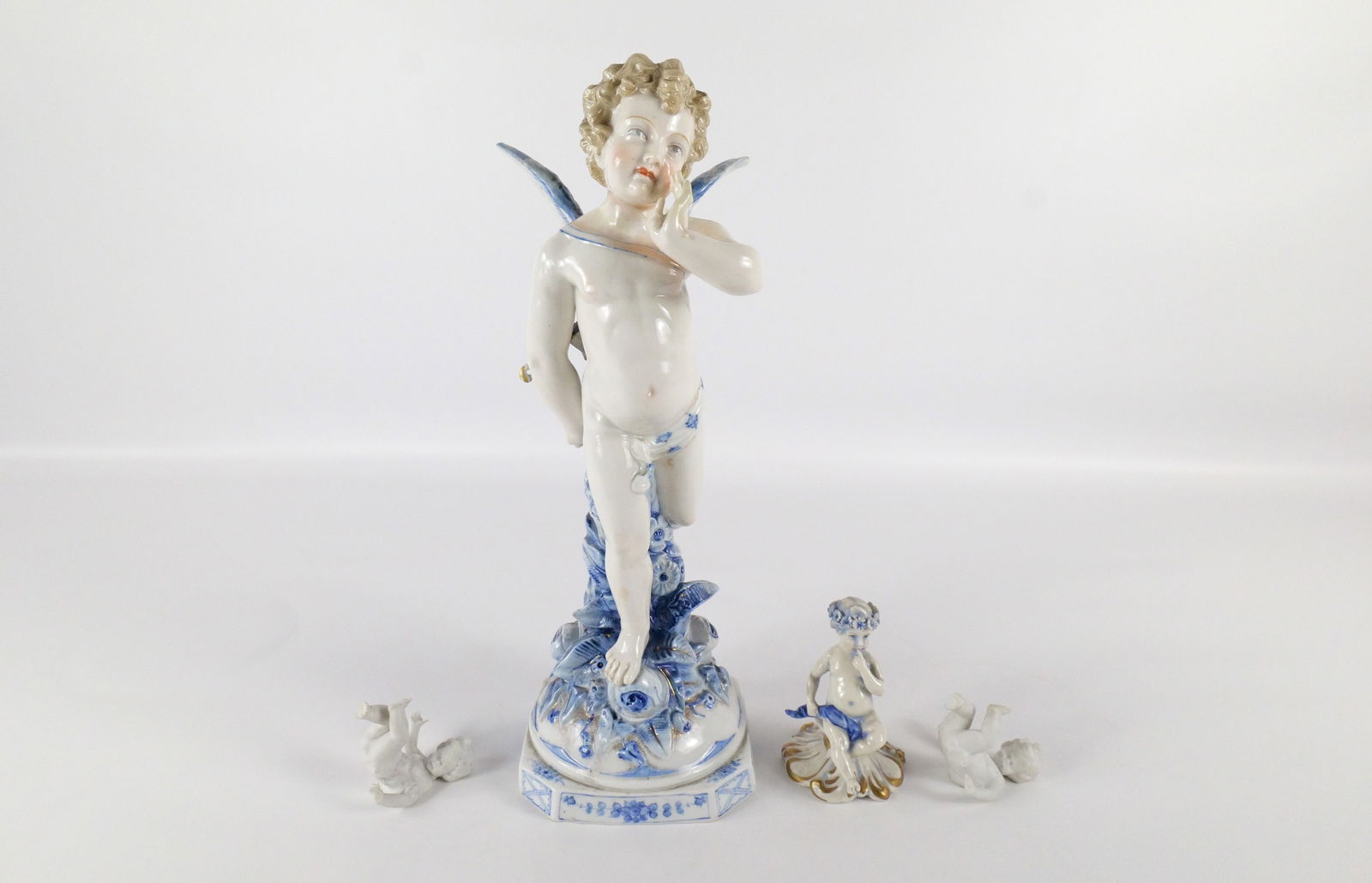 Group Lot of Figurines: Group Lot of Figurines. Including 19th Century German Oversized Cherub Figurine, Capodimonte Putti Figurine, and Pair of German Orlik Putti Miniature Figurines. The miniatures have missing fingers. La