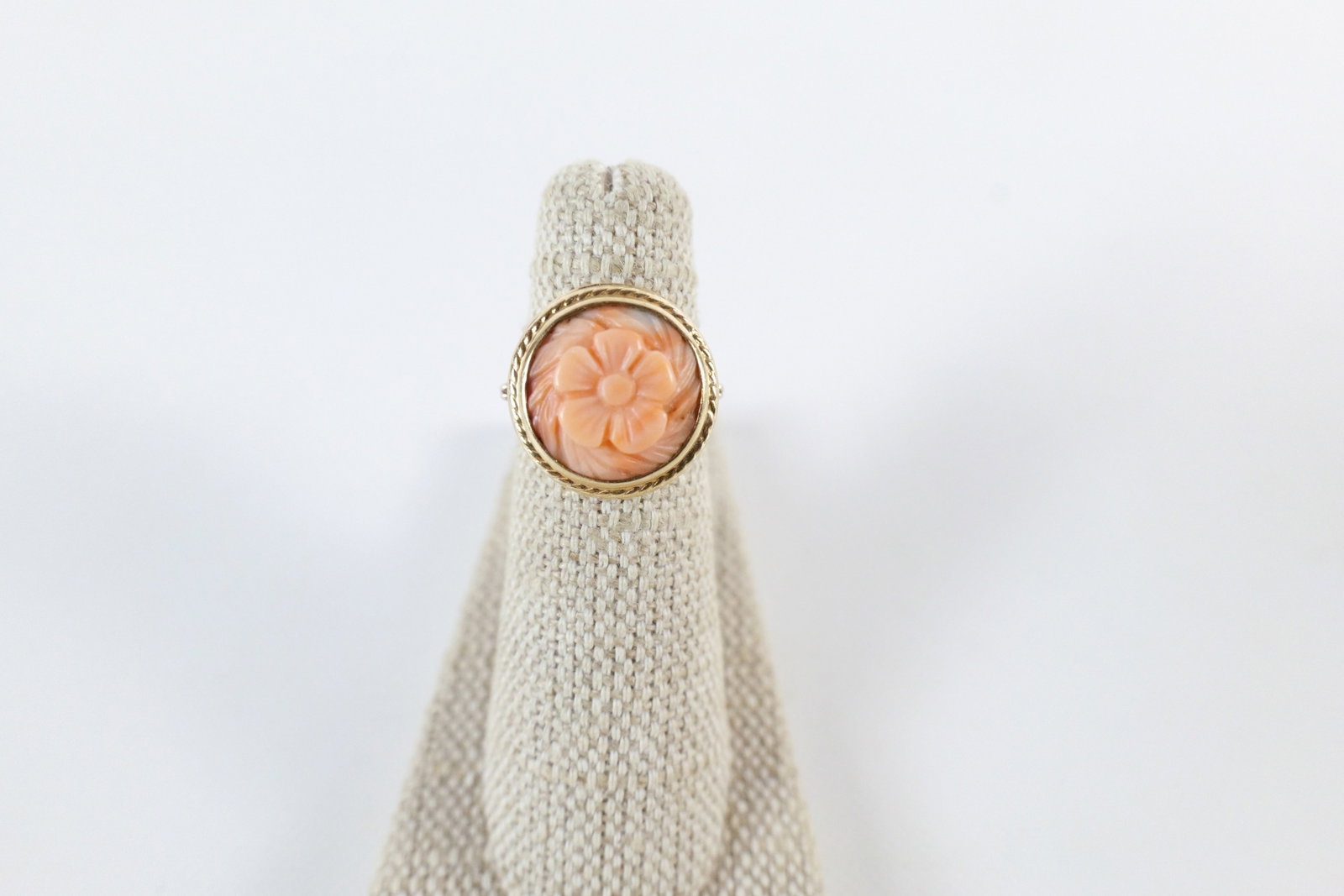 Vintage 10K Carved Coral Ring: Vintage 10K Carved Coral Ring. The lot includes a sz 5 vintage 10K yellow gold ring set with a 14mm round peachy pink floral carved coral cabochon in a neoclassical inspired setting. Marked 10K and us