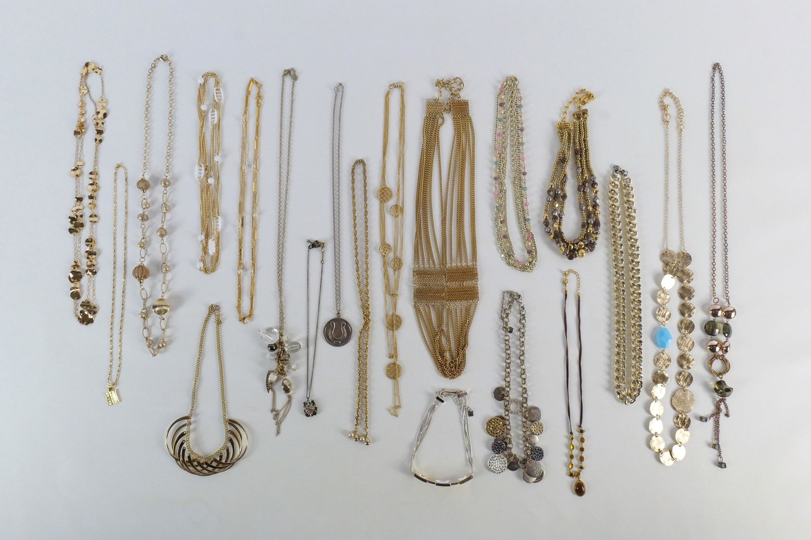 Group of Gold Tone Costume Jewelry: Group of Gold Tone Costume Jewelry. The lot includes a mix of 16 vintage and modern gold tone costume jewelry necklaces and more. The necklaces ranging in length from 58'' to 15.5'''' long and includi