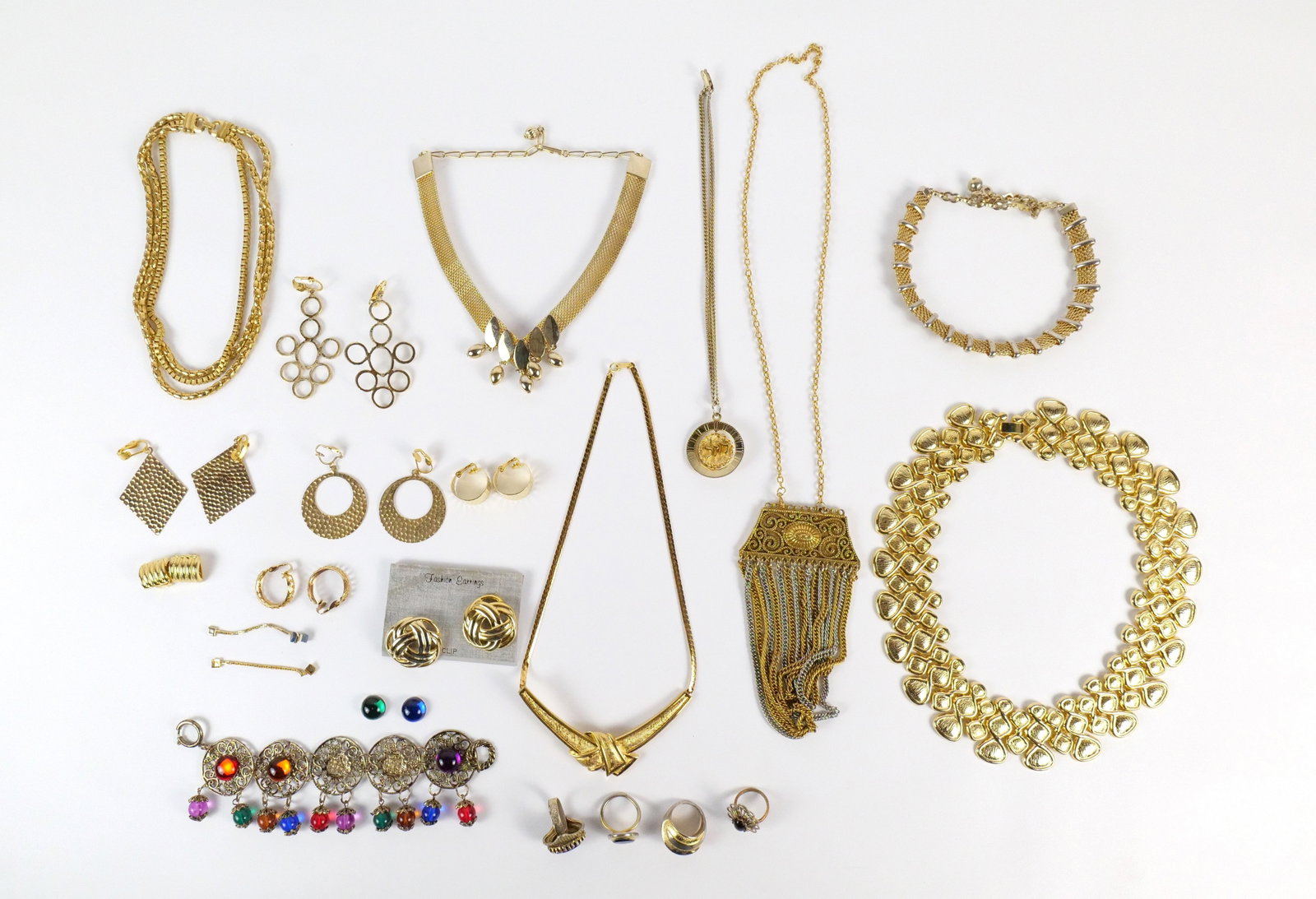 Group of Vintage Gold Tone Costume Jewelry: Group of Vintage Gold Tone Costume Jewelry. The lot includes a variety of vintage gold tone costume necklaces, bracelets, earrings, and rings. Featuring a 24'' long vintage 70s necklace with a large 5