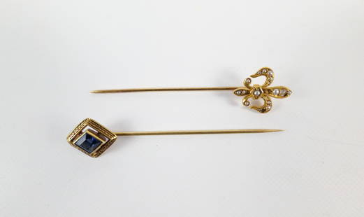 Pair of Early 20th Cenury 14K Stick Pins: Pair of Early 20th Century 14K Stick Pins. The lot includes a pair of early 20th century 14K yellow gold stick pins. Featuring a 2.5'' long fleur de lis stick pin set with halved seed pearl accents. T