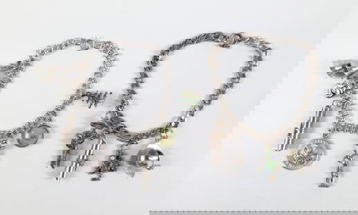 Pair of Vintage Sterling Charm Bracelets: Pair of Vintage Sterling Charm Bracelets. The lot includes a pair of vintage 1960s sterling charm bracelets. Featuring a 7.5'' long sterling Cuban link bracelet with a spring ring closure and four att