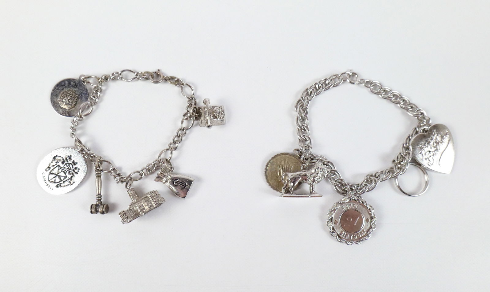 Pair of Vintage Sterling Charm Bracelets: Pair of Vintage Sterling Charm Bracelets. The lot includes a pair of vintage 1960s sterling charm bracelets. Featuring a 7'' long sterling figaro link bracelet with a spring ring clasp and 6 silver to