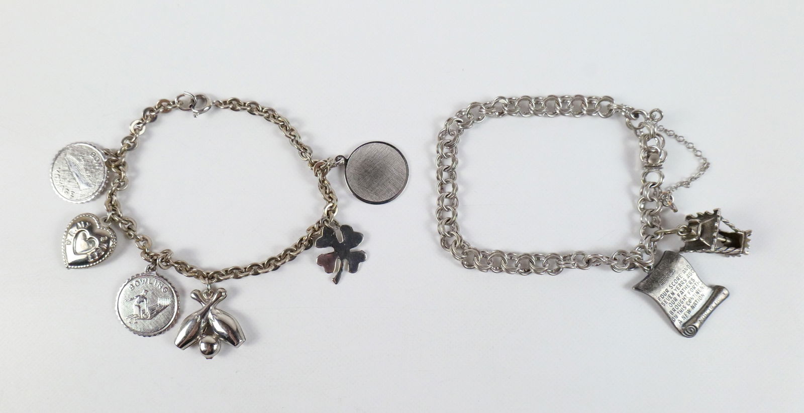 Pair of Vintage Sterling Charm Bracelets: Pair of Vintage Sterling Charm Bracelets The lot includes a pair of vintage 1960s sterling charm bracelets. Featuring an 8'' long round link bracelet with a spring ring clasp and 6 sterling charms in