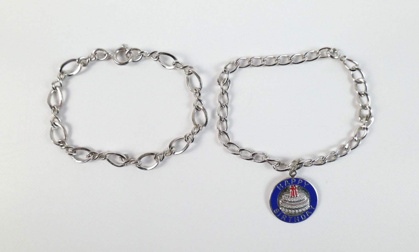 Pair of Vintage Sterling Charm Bracelets: Pair of Vintage Sterling Charm Bracelets. The lot includes a pair of sterling charm bracelets Featuring a 7'' long sterling large and small oval link bracelet with a spring ring clasp and not charms,