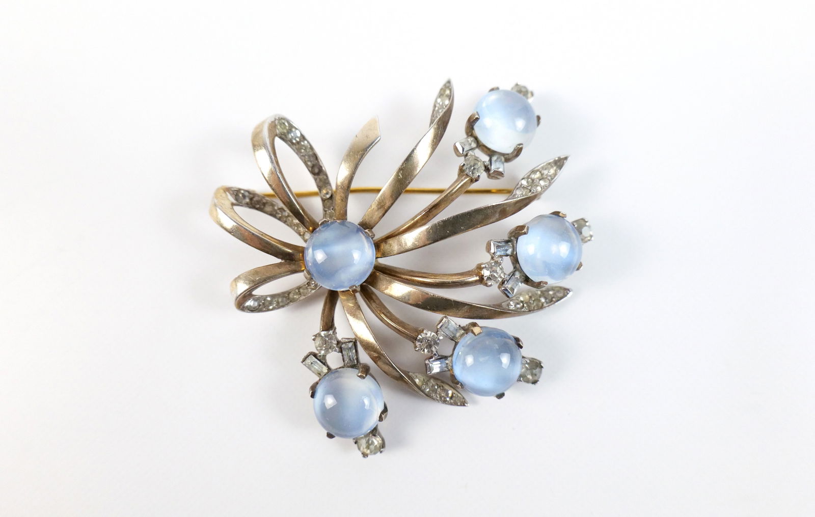 Vintage 1940s Sterling Mazer Brooch : Vintage 1940s Sterling Mazer Brooch. The lot includes a vintage 1940s 2.53'' x 2.46'' gold vermeil sterling bow-like brooch by Mazer featuring rounds light blue class cabochons and white rhinestone ac