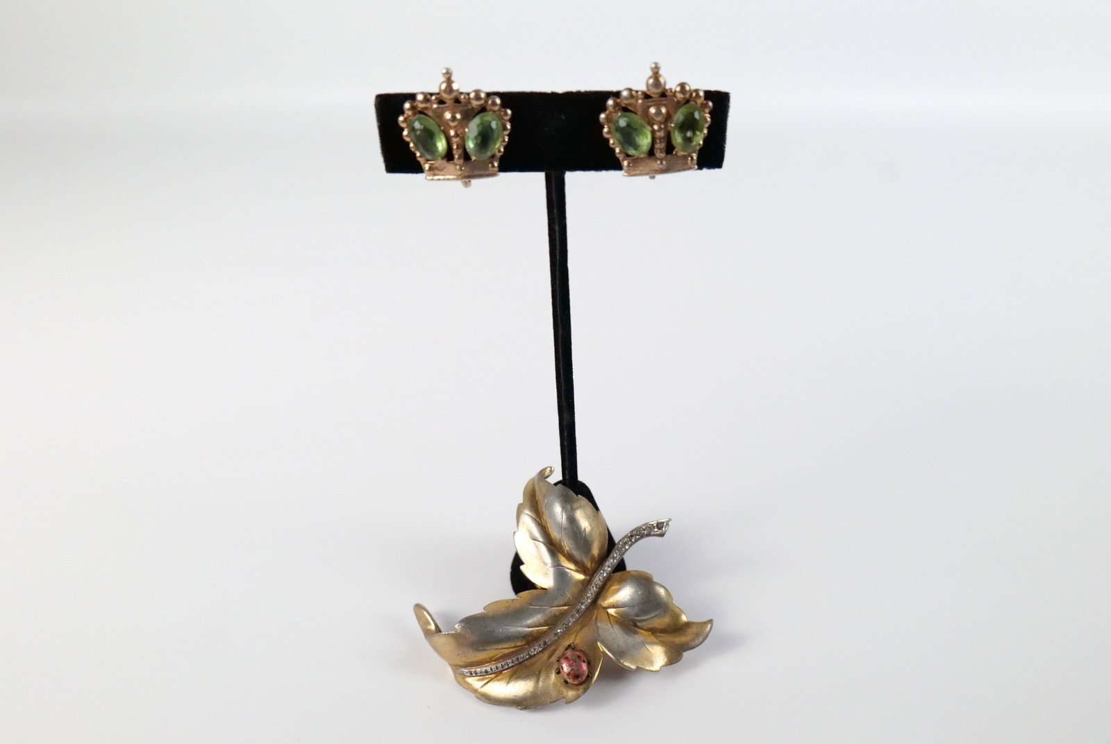 1940's Fur Clip and Earrings: 1940's Fur Clip and Earrings. The lot includes a vintage 1940s fur clip and earrings. Featuring a 2.19'' x 2.43'' gold vermeil leaf fur clip with a rhinestoned stem and a lady bug, it has double bar c