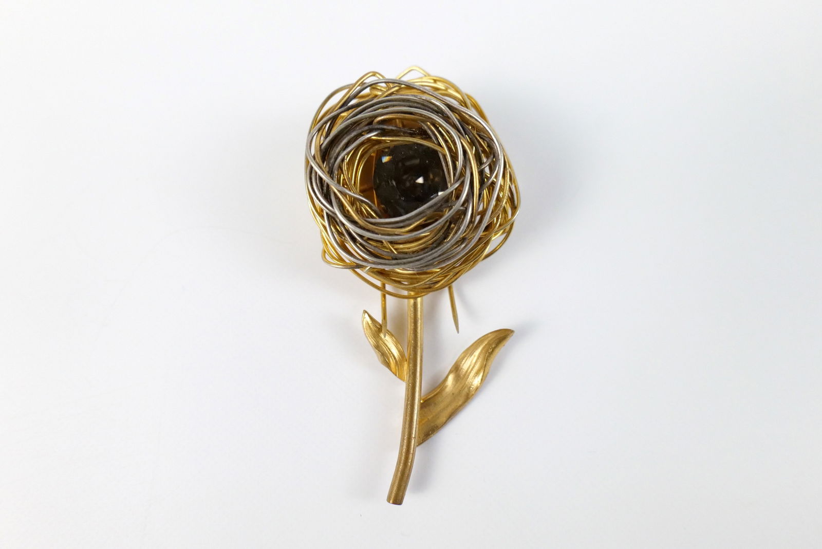 Midcentury Gold Tone Depose Fur Clip : Midcentury Gold Tone Depose Fur Clip. The lot includes a vintage 3.11'' x 1.50'' gold and silver tone flower fur clip by Depose featuring a nest-like bloom with a large faux smokey quartz gem at its c