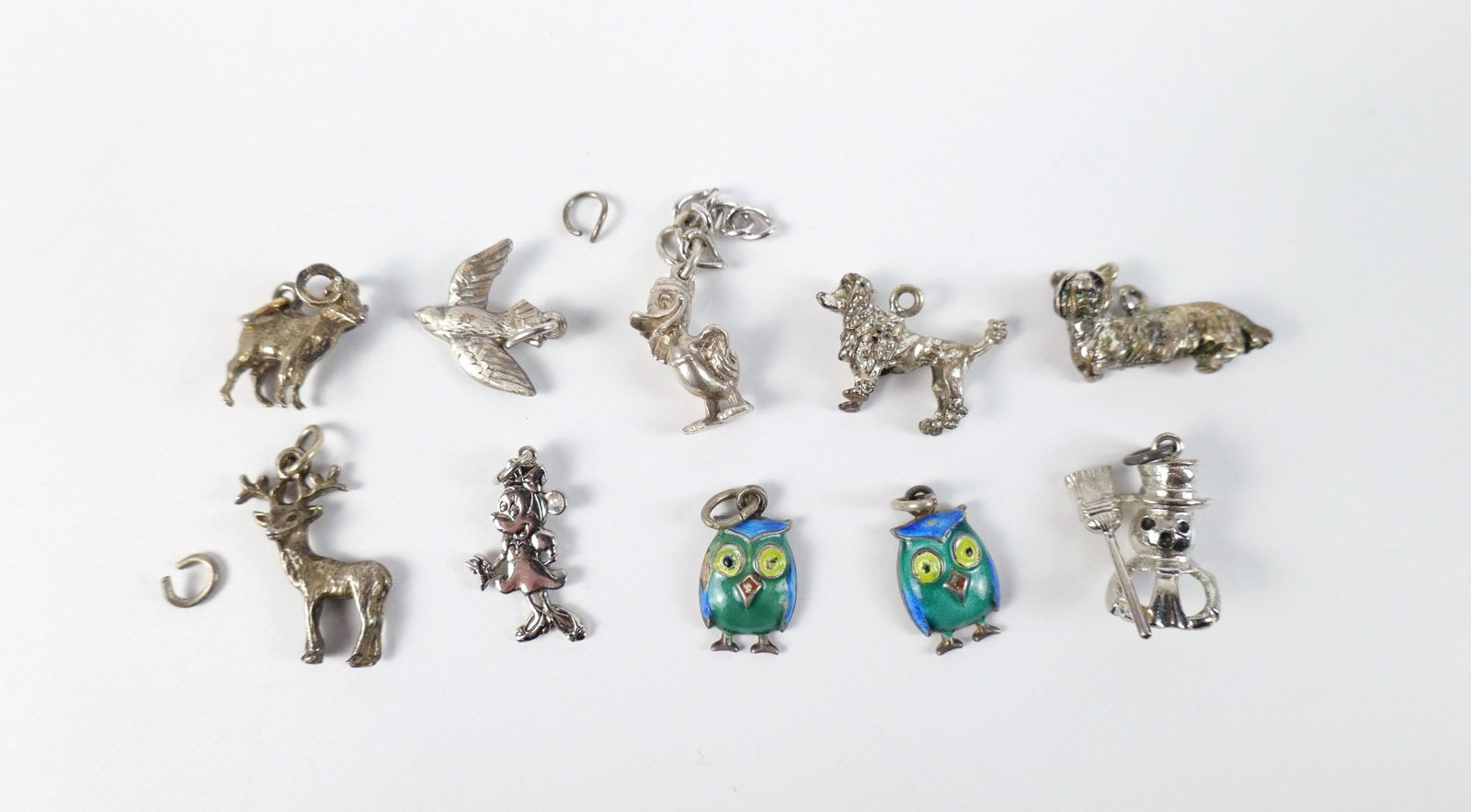 Group of 10 Vintage Sterling Animal Charms : Group of 10 Vintage Sterling Animal Charms. The lot includes a mix of 10 vintage sterling animal charms including Minnie Mouse, an early Donald Duck, a poodle, a terrier, a dove, a ram, a deer, a snow
