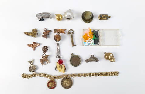 Group of 19 Vintage Charms: Group of 19 Vintage Charms. The lot includes a mix of 19 vintage metal and plastic charms. Including a silver tone trailer, a framed Canadian penny, a pair of tennis rackets, a Haverford School